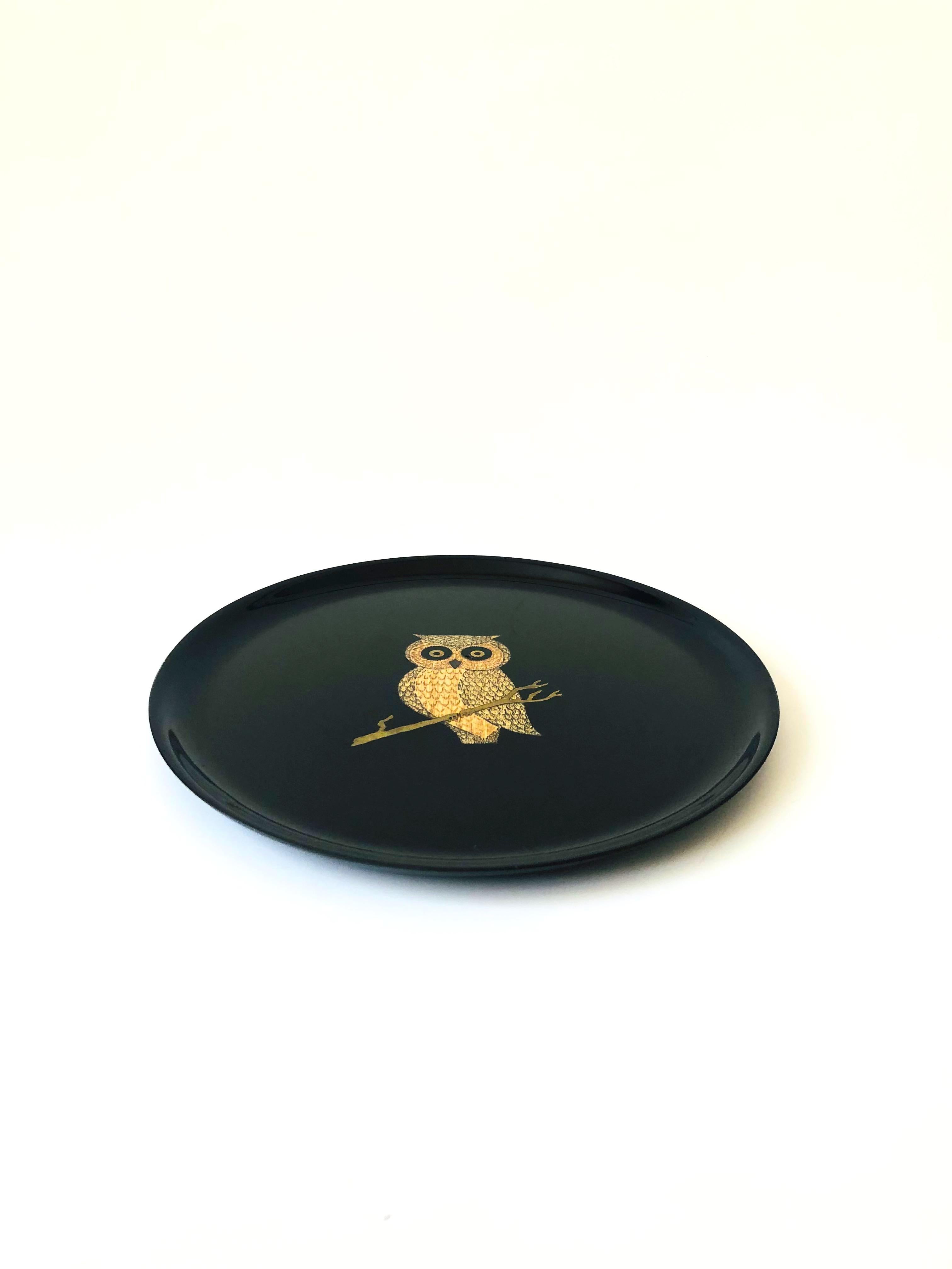 A wonderful vintage circular tray. The image of an owl in the center of the dish is formed from small pieces of inlaid shells, coins, woods, and metals fused into a satin black durable plastic-like material called phenolic. Made in Montery,