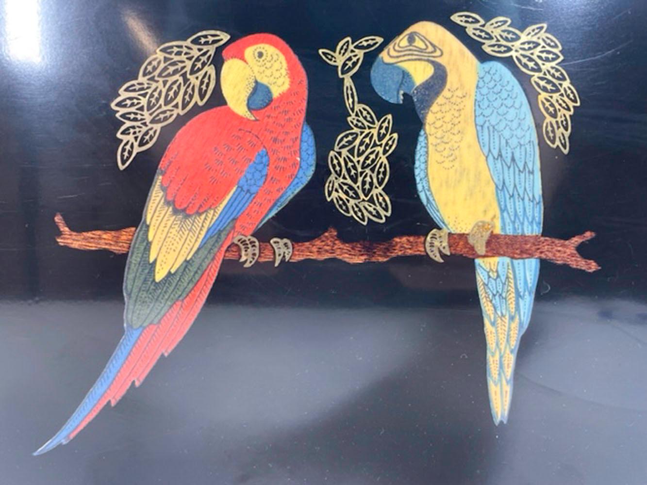 Vintage serving tray by Couroc of Monterey, made of phenolic resin inlaid with brass and stained wood depicting a pair of brightly colored macaws on a branch.
Phenolic resin is resistant to damage from alcohol and hot water, making it ideal for use