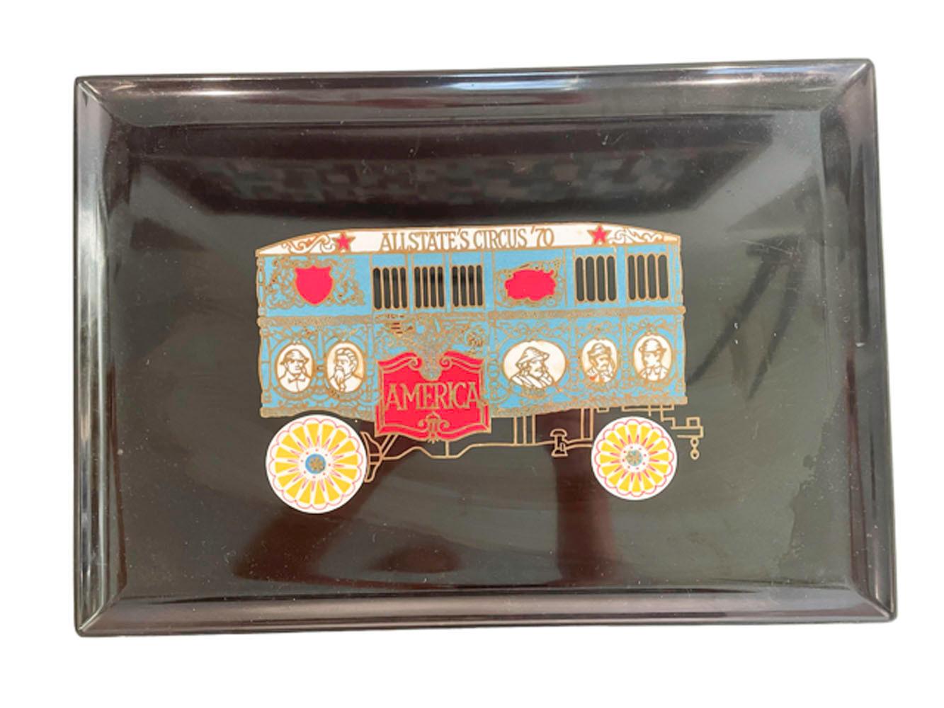Vintage mid-century modern rectangular serving tray made of black phenolic resin, inlaid with brass and colored resins. This tray depicts a brightly colored c.1900 image of a circus train. Phenolic resin has properties which make it resistant to