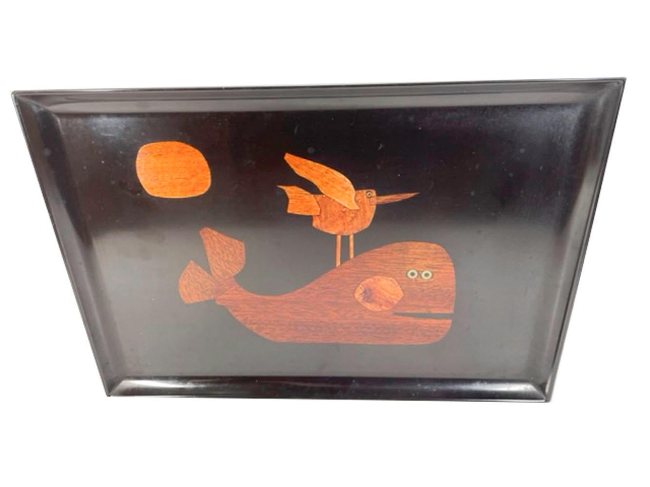 Mid 20th century serving tray by Couroc of Monterey, made from Phenolic resin and inlaid with wood and brass depicting a whale with a bird perched on its back and the sun in the sky. Phenolic resin is resistant to damage from alcohol and water.