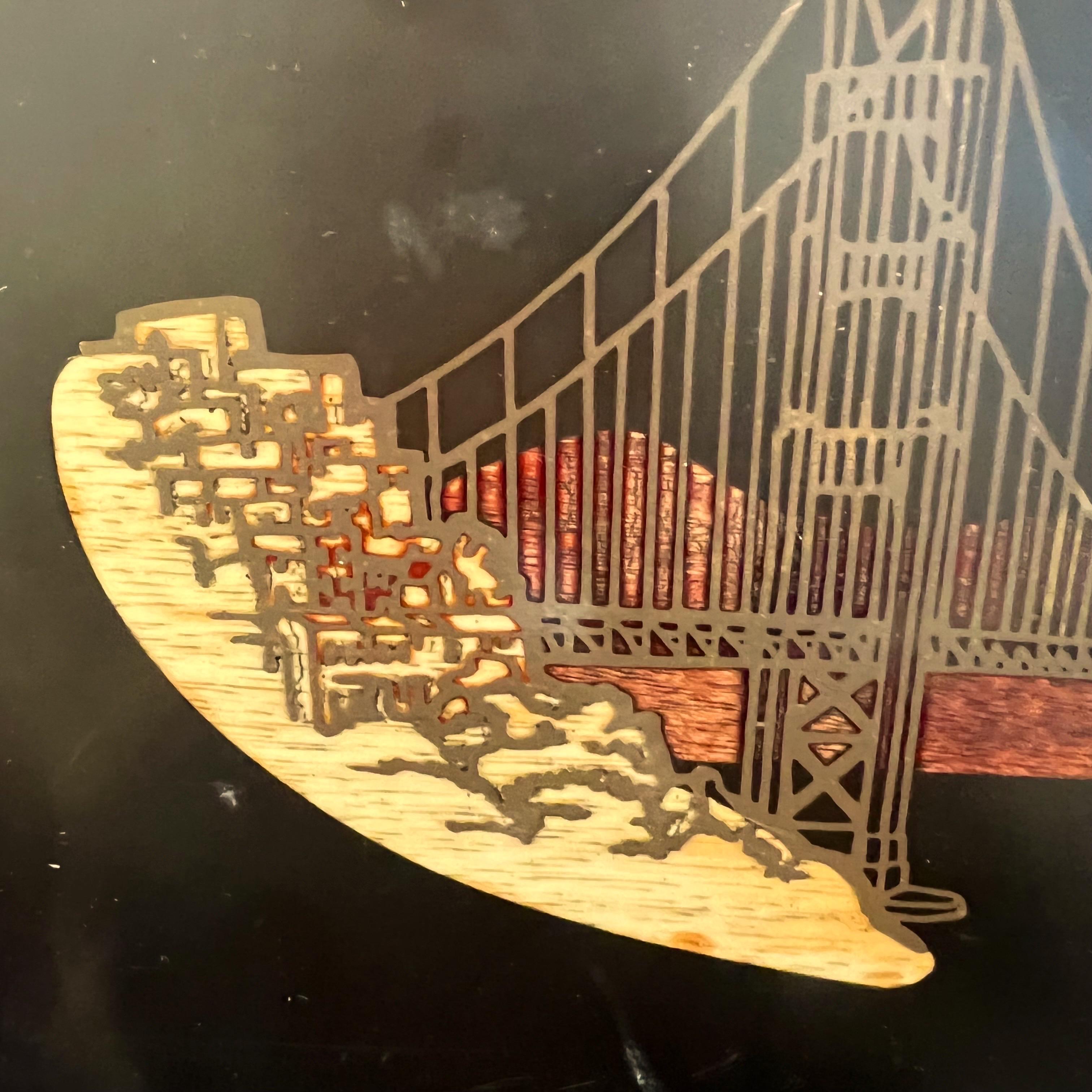 Vintage Couroc San Francisco Golden Gate Bridge tray. This black tray is 12.5” by 9.5” in size. It is inlaid with brass and wood, and has a subtle curved edge and 4 little feet on the bottom. It has its original sticker on the back. Excellent