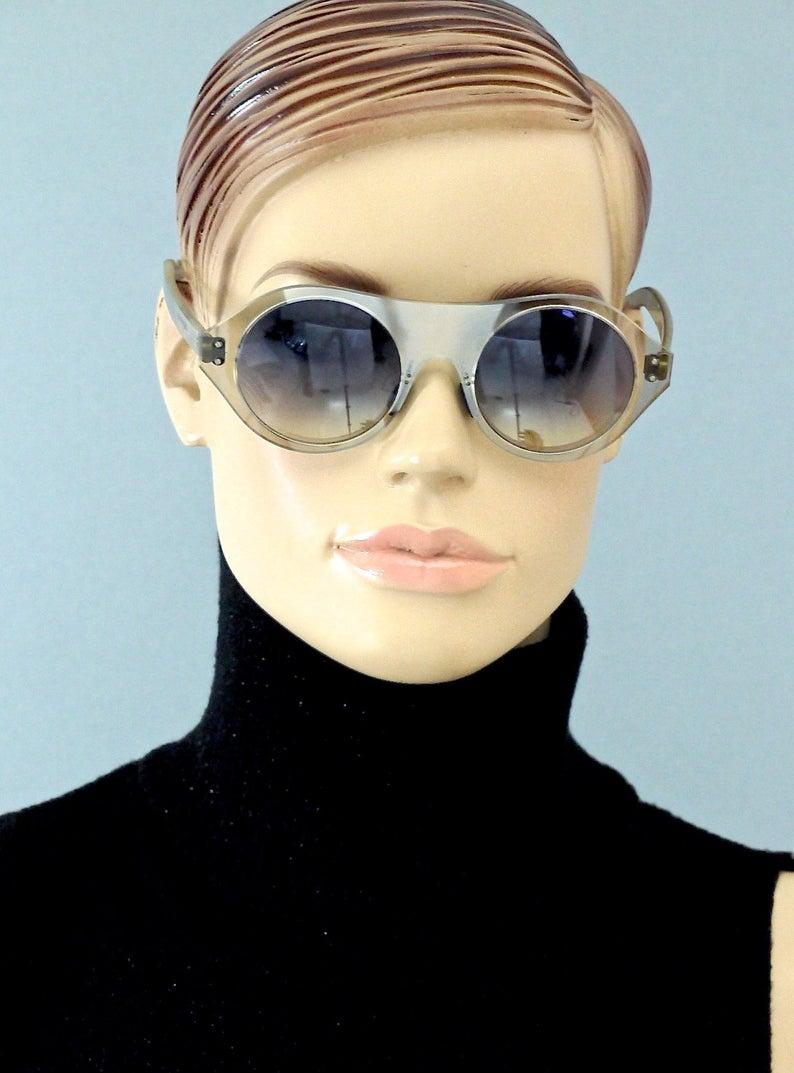 Vintage COURREGES Clear Futuristic Space Age Sunglasses

Measurements:
Frame Height: 2 inches (5.1 cm)
Hinge to hinge Width: 5.41 inches (13.75 cm)
Temples: 5.59 inches (14.2 cm)

Features:
- 100% Authentic ANDRE COURREGES.
- Futuristic, space age