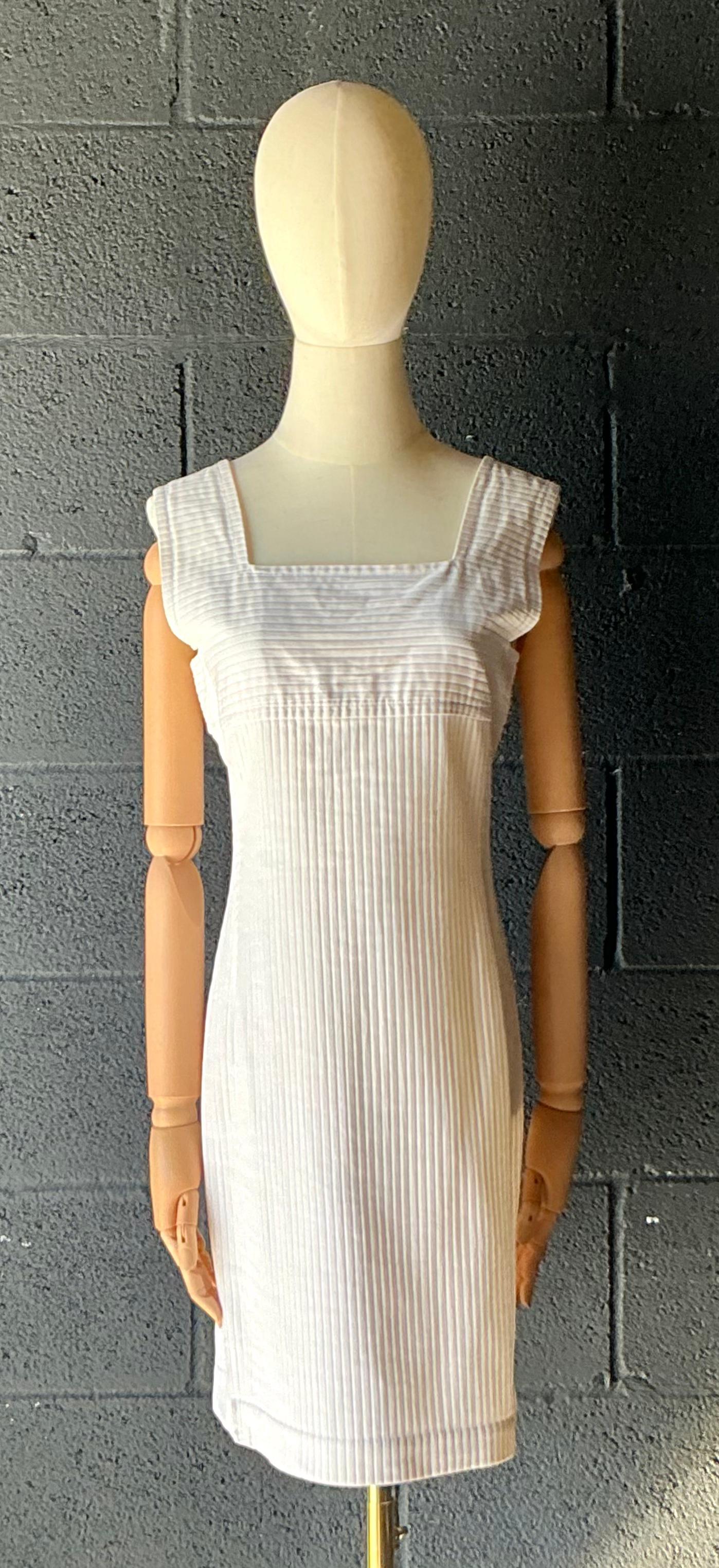 Das weiße gerippte Vintage Courrèges-Kleid ist ein zeitloses und ikonisches Stück, das die minimalistische Eleganz der französischen Mode der 1960er Jahre verkörpert. Mit seinen klaren Linien, der gerippten Textur und der klassischen weißen Farbe