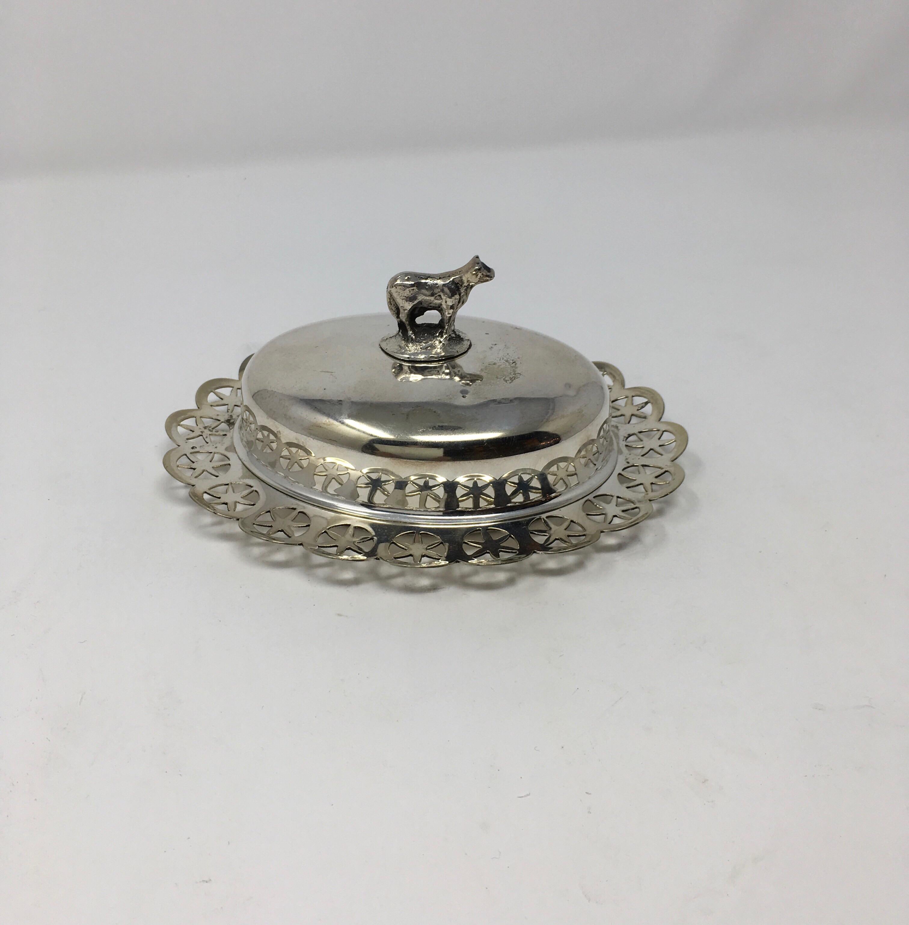Found in England, this is a lovely covered butter dish with a standing cow finial on the cover. The server consists of three pieces, tray, dish and cover. The tray has a star pattern and measures 5