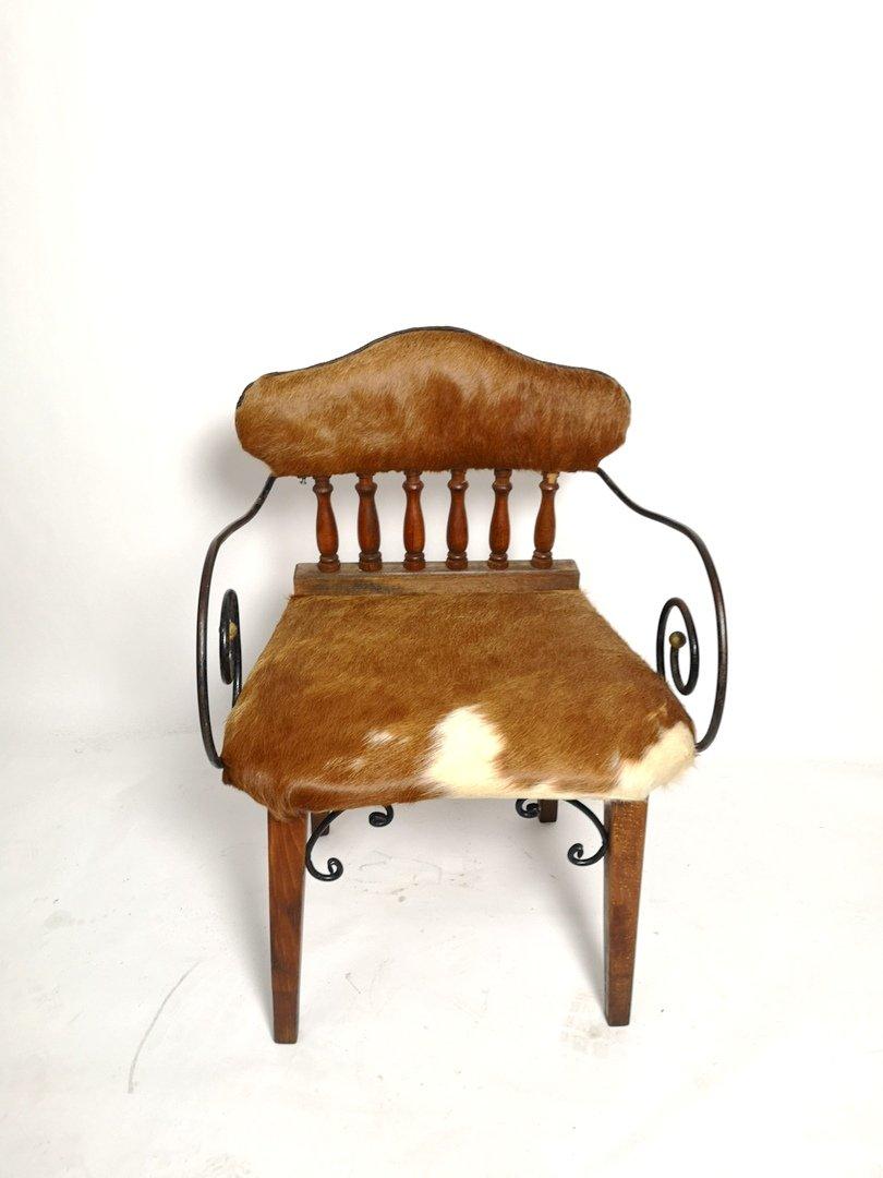 This antique chair features a remade cow-hide leather seating and refinished oak surface, with the original iron and brass accessories and armrest.
This vintage item has no defects, but it may show slight traces of use.
Light wear consistent with