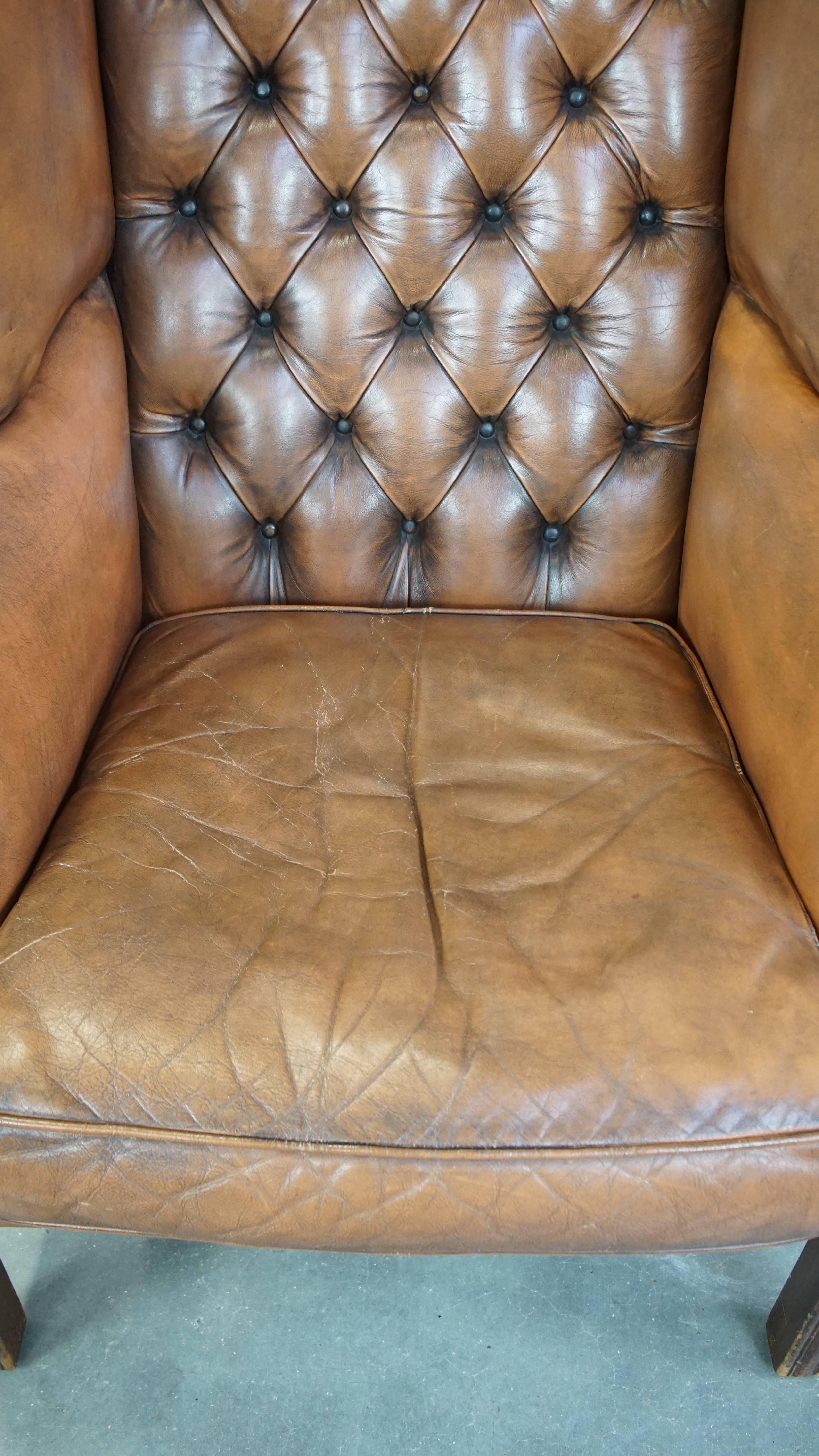 Cowhide Vintage cowhide leather English Chesterfield wingback chair, light cognac color For Sale