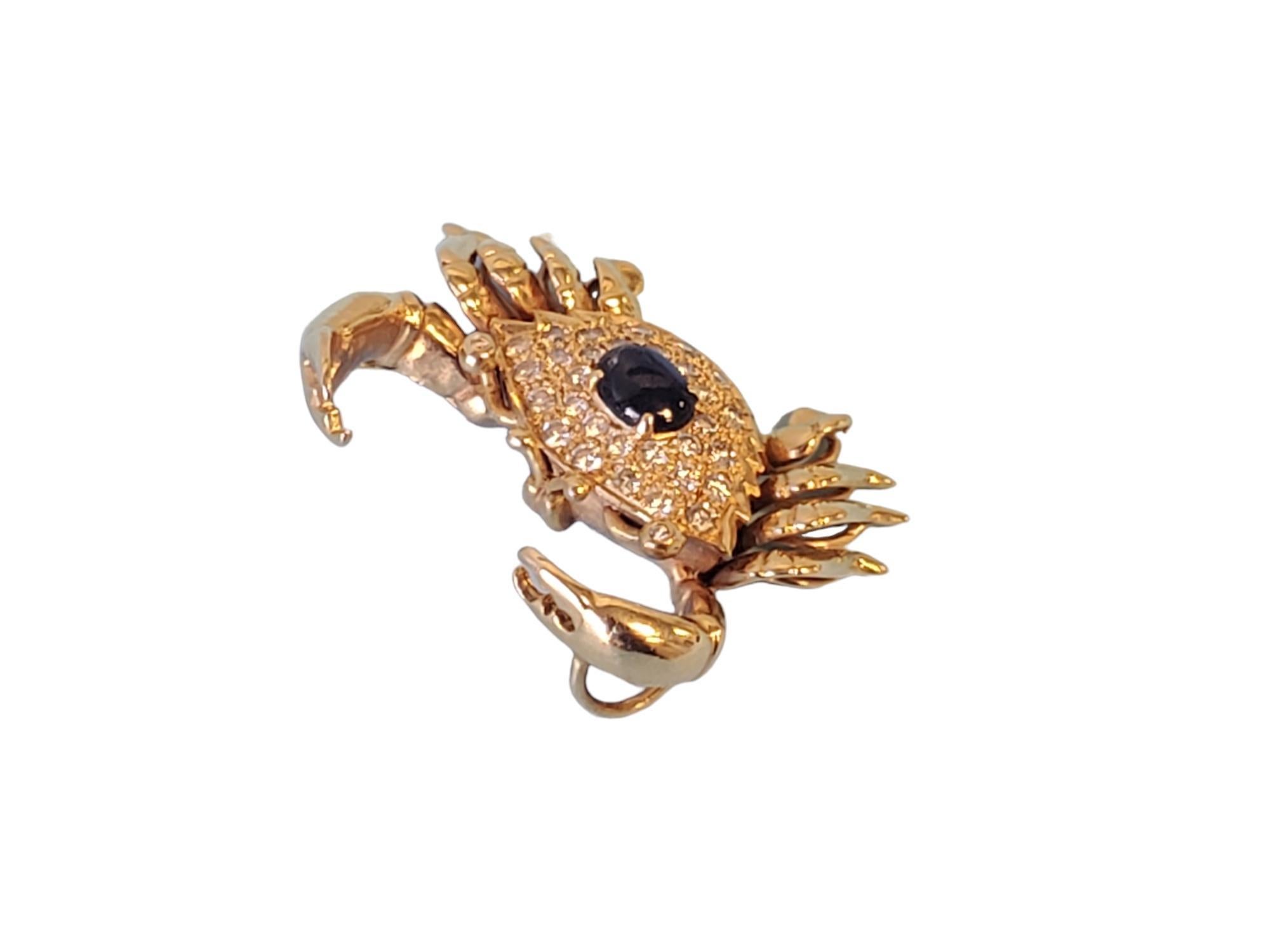 Listed is a vintage crab slide pendant in 14k yellow gold. The piece is in excellent condition and features approximately 1tcw diamonds H VS quality round brilliant diamonds with an approximately .75-1ct blue oval sapphire cabochon. Its a wonderful