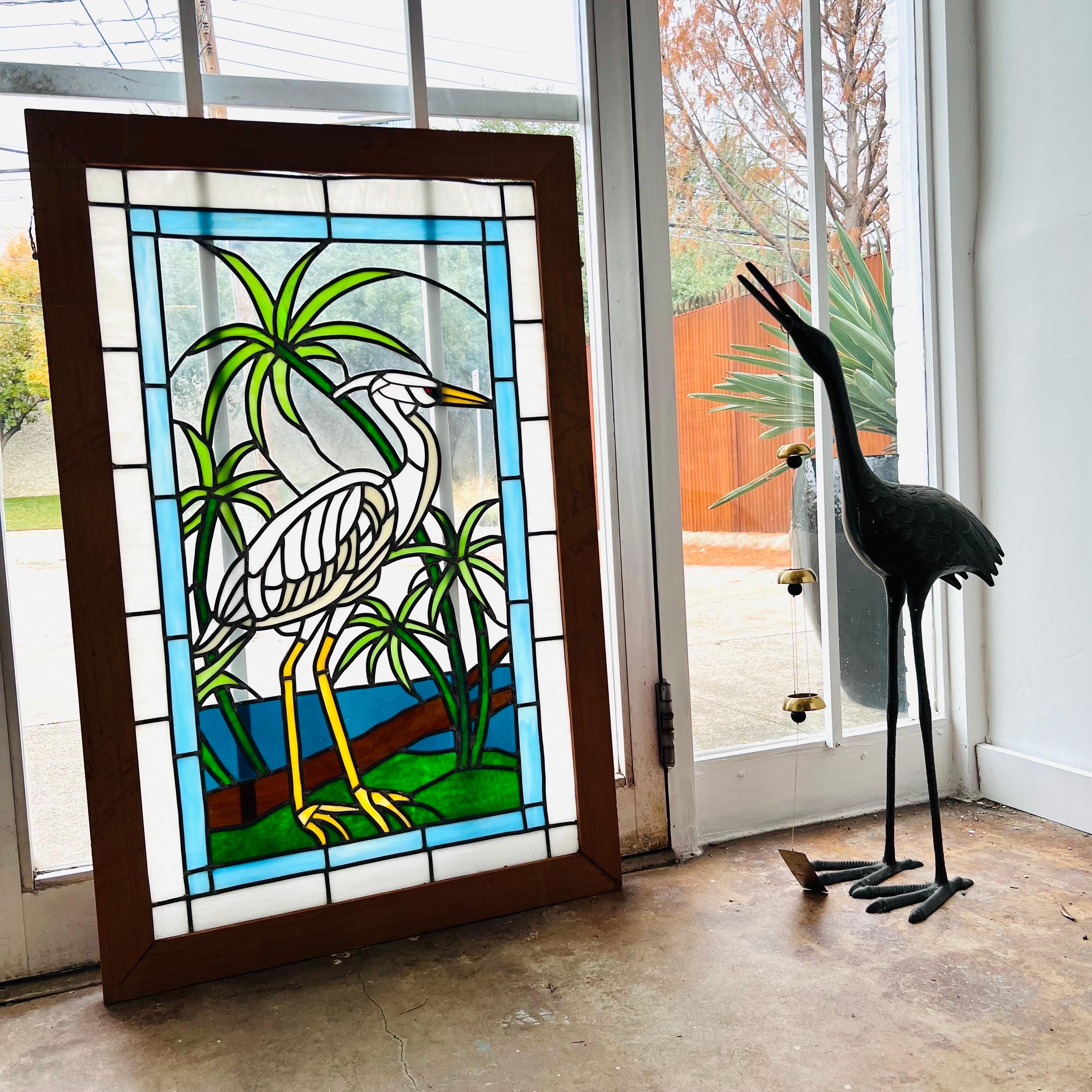Vintage framed stained glass panel featuring a crane with palm trees. Some cosmetic imperfections with frame (pictured) but no breaks in glass, good vintage condition.