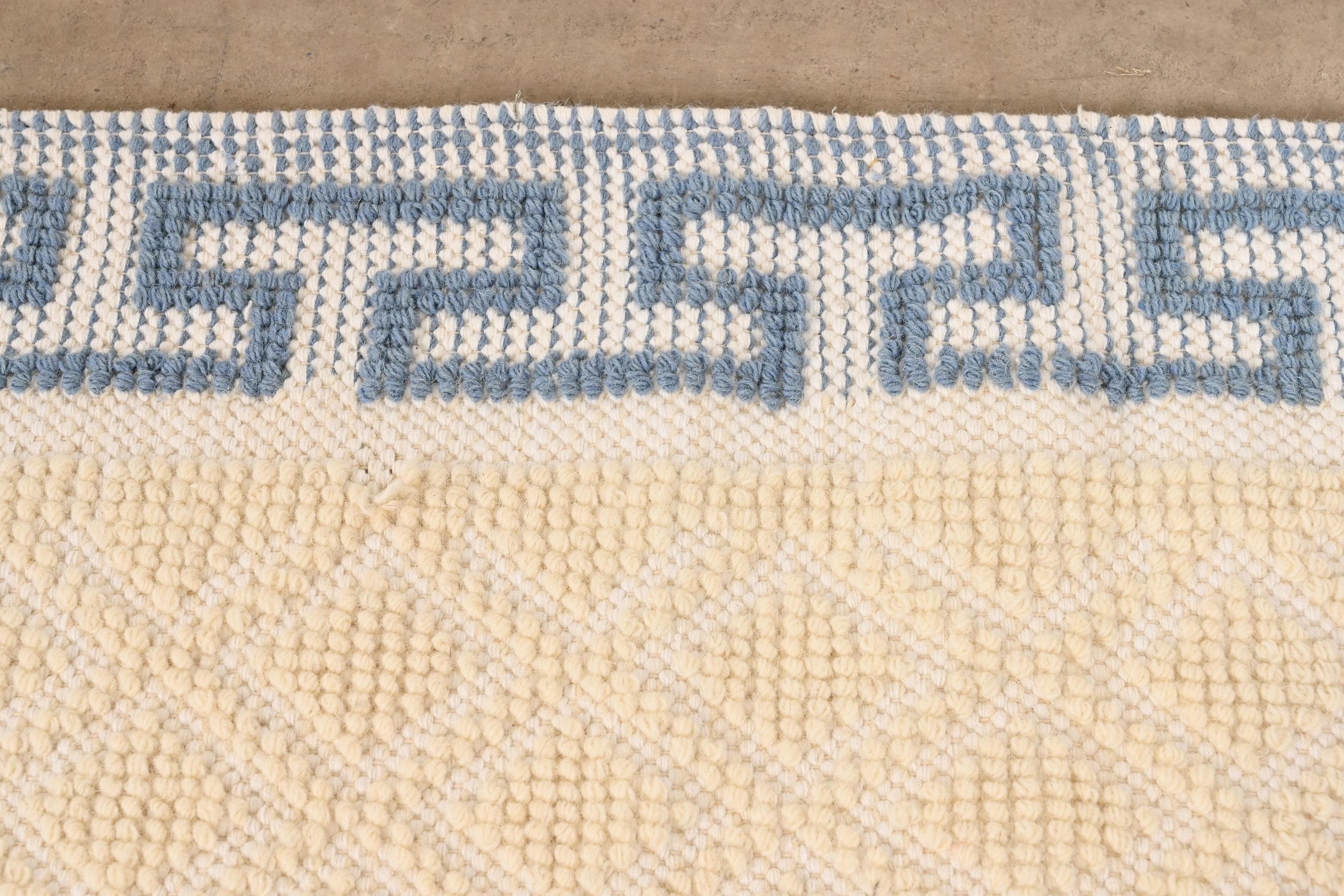 white rug with blue border