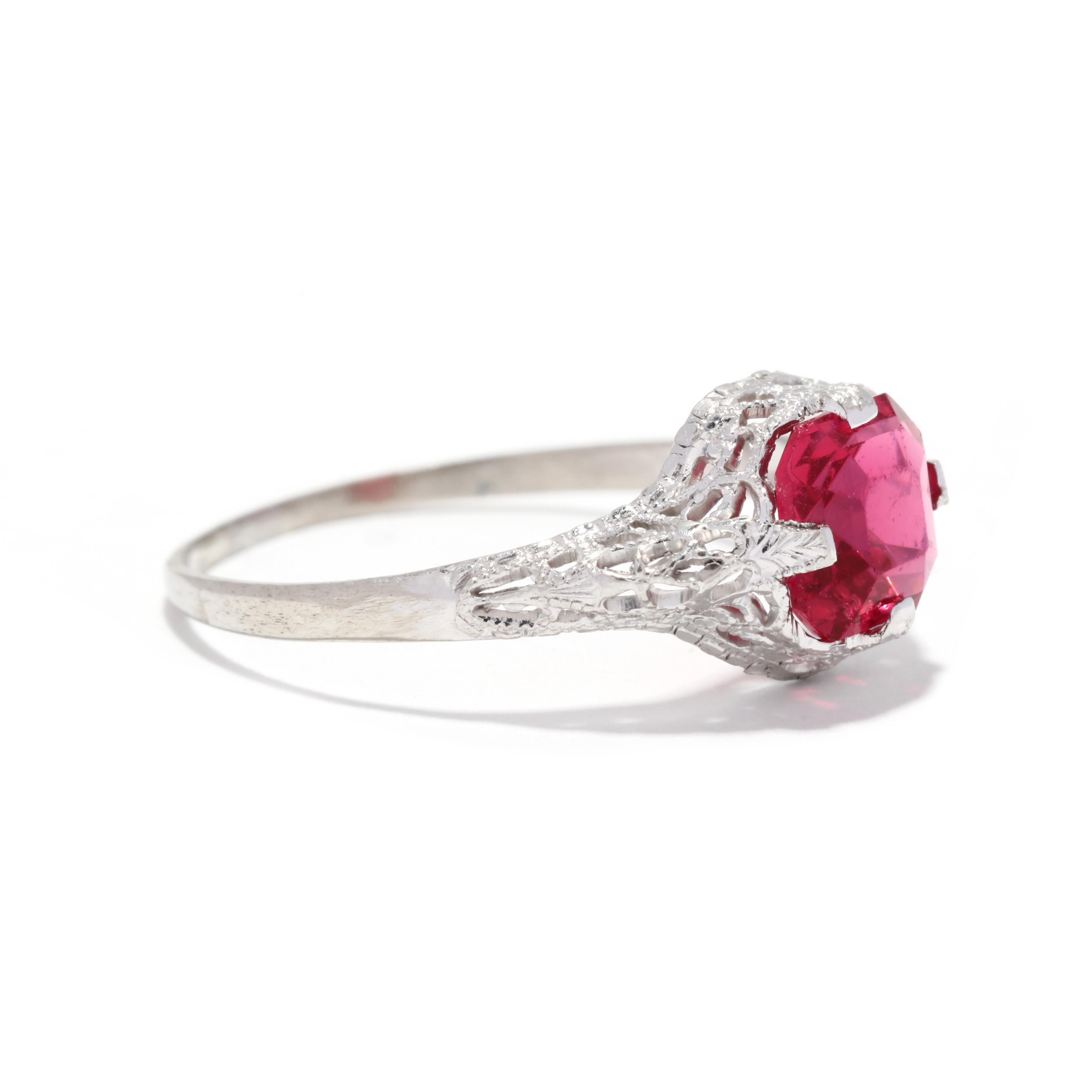 A vintage 10 karat white gold created ruby filigree ring. This ring features an asscher cut created ruby weighing approximately 1.15 carats, prong set in a floral filigree ring with milgrain detailing.

Stones:
- created ruby, 1 stone
- asscher