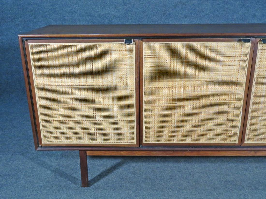 Beautiful vintage credenza pairing walnut and woven cane. Four doors swing open to reveal spacious compartments and two large drawers. This sturdy Mid-Century piece is full of vintage craftsmanship and style. Please confirm item location with seller