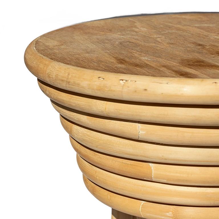 Une table d'appoint ronde vintage en rotin avec un plateau en bois et un design moderne minimaliste et organique. Les couches de rotin courbé combinées à la finition naturelle légère rappellent les magnifiques designs de Gabriella Crespi des années