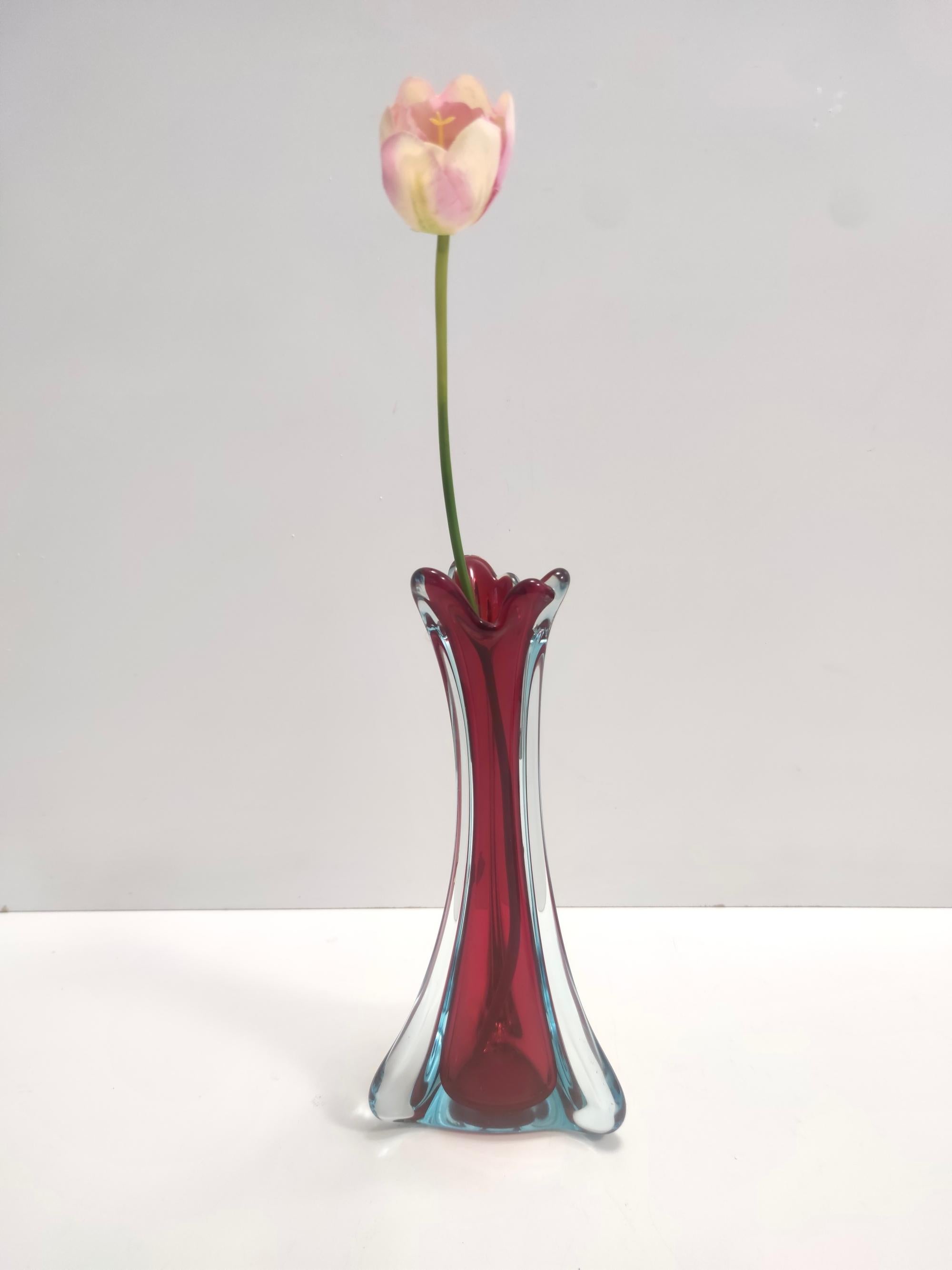 Hergestellt in Italien, 1960er Jahre. 
Diese Vase ist aus Murano-Glas von Sommerso gefertigt, das in drei verschiedenen Farben mundgeblasen wurde: transparent, karminrot und hellblau.
Es hat sein originales Label. 
Da es sich um einen