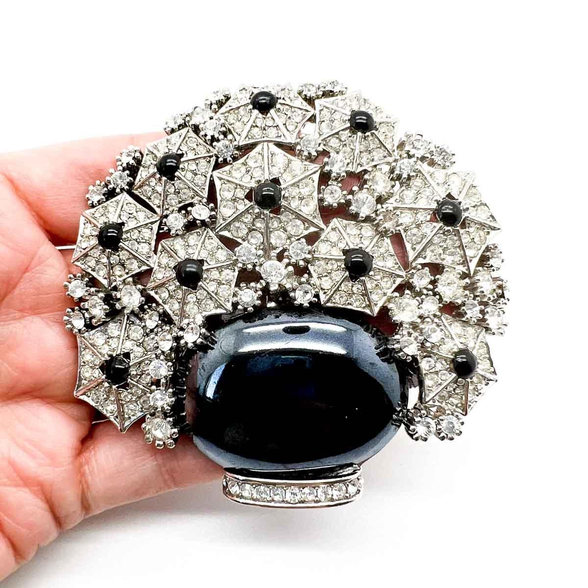 Une spectaculaire broche Vintage Cristobal Giardinetti. Par le joaillier londonien Cristobal. Il s'agit d'un grand pot de fleurs stylisées au design art déco très accrocheur et aux couleurs monochromes. Celui-ci est une pure joie pour le revers de