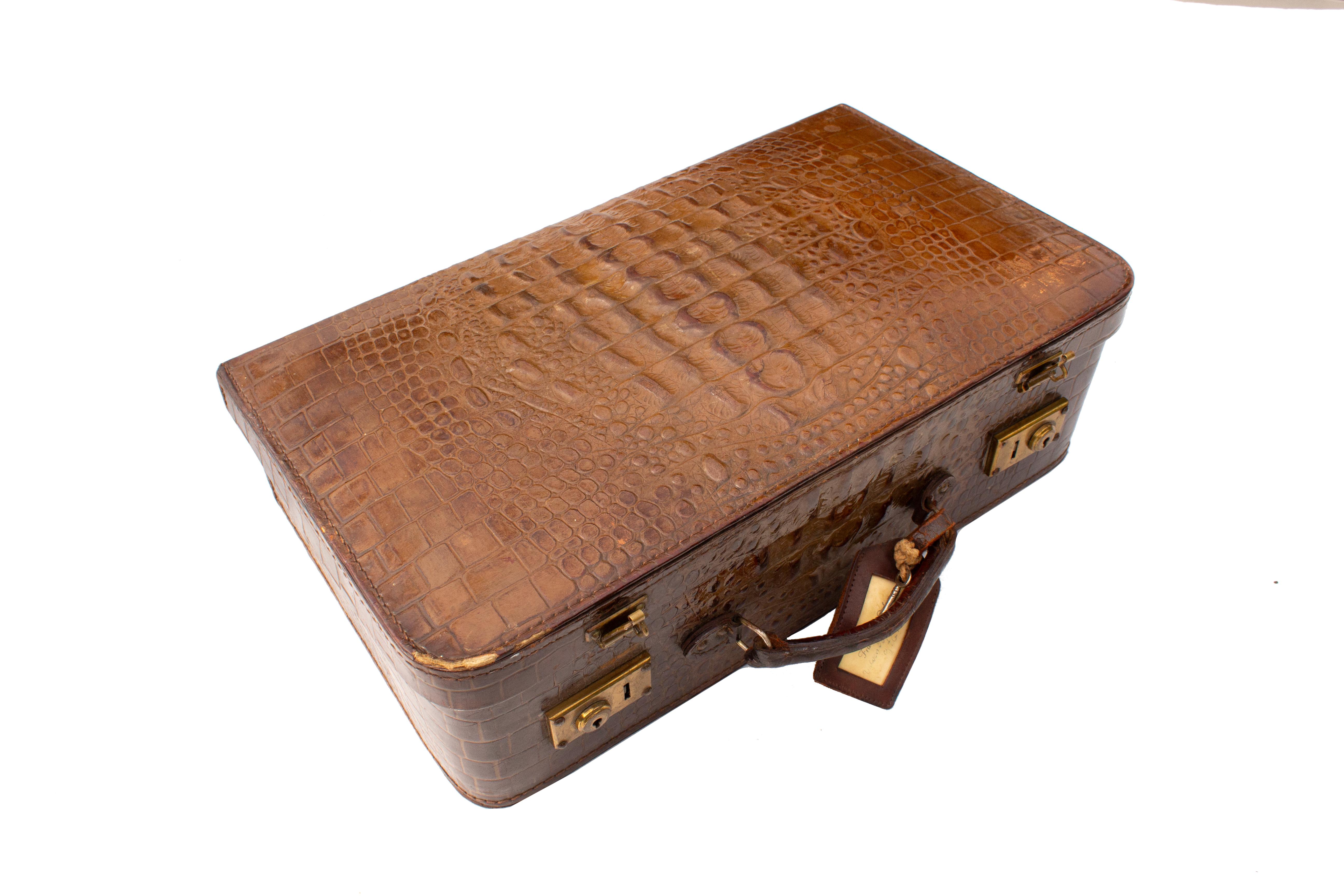Vintage Crocodile Leather Hornback Suitcase, Storage Case. Le cuir présente une superbe teinte brune, accentuée par le relief du crocodile sur le dessus de la valise. La quincaillerie en laiton est livrée avec une clé, ce qui permet de fixer les