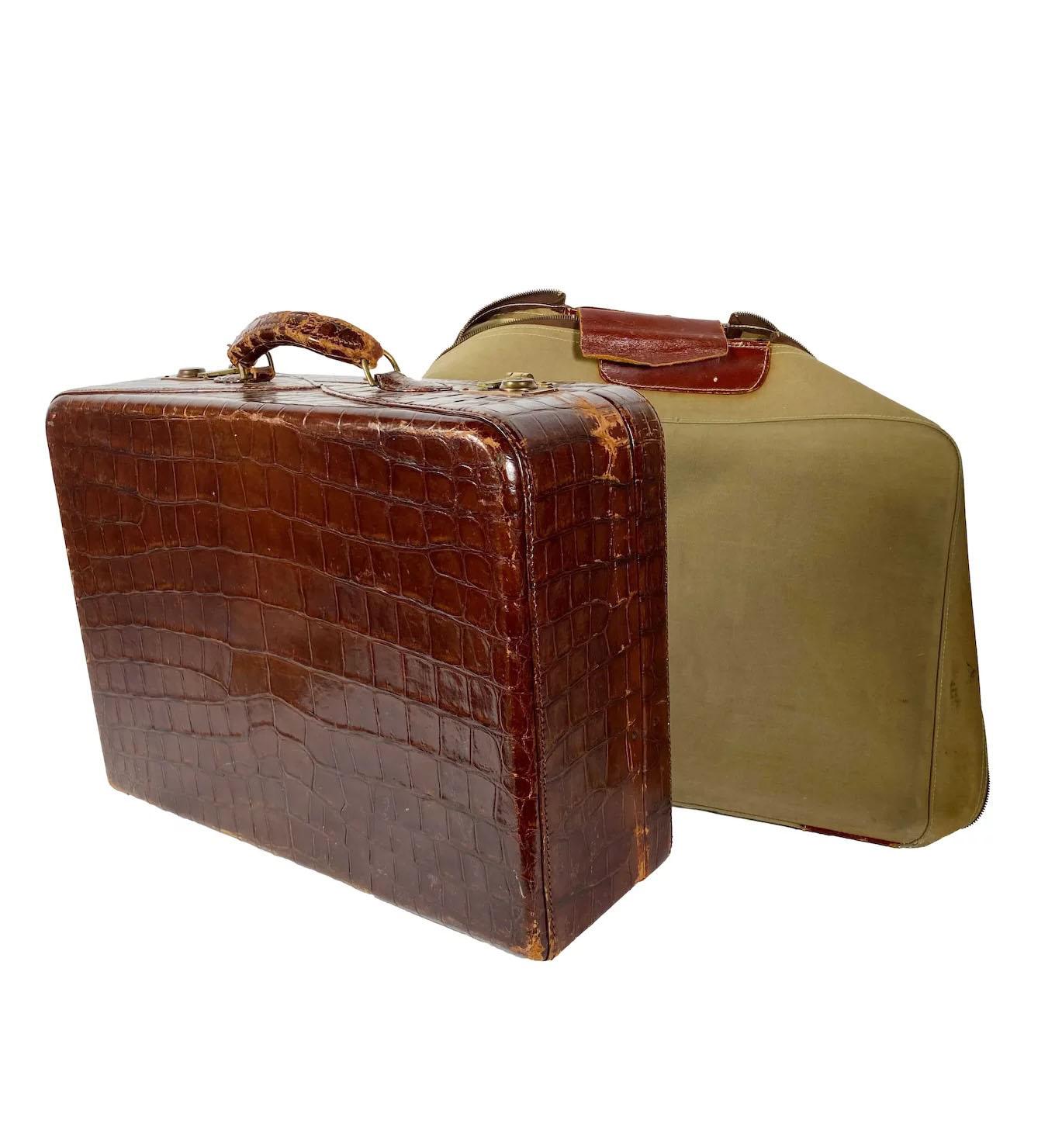 Mid-20th century, dark crocodile hide exterior, satin interior and custom fitted canvas cover. Individual characteristics are as follows: Suitcase has wear to handle; a few scuffs; internally clean and sound; suitcase has maker's plate and no