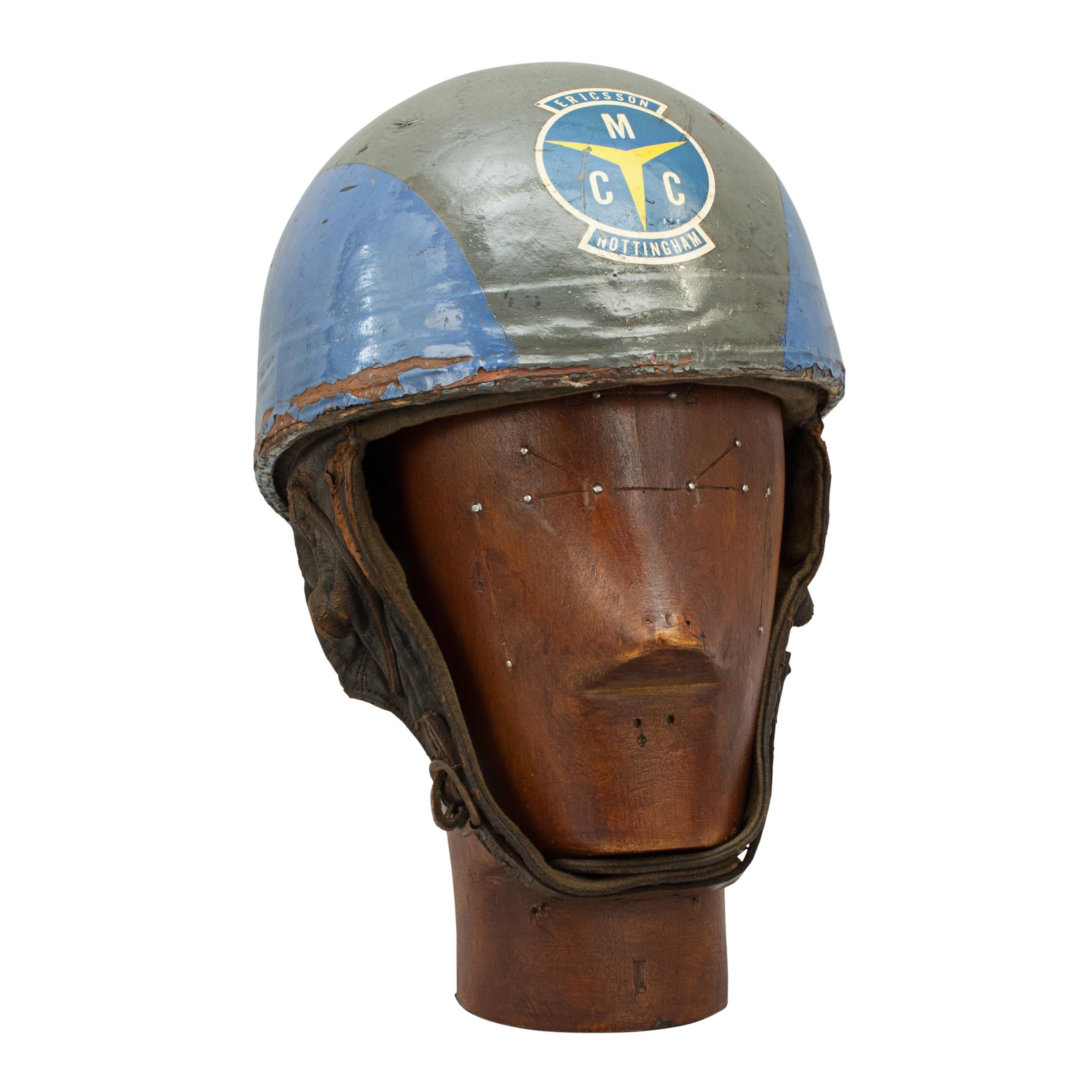 Vintage Cromwell motorcycling crash helmet.
A blue and grey motorcycle, pudding basin shape helmet made in England by Cromwell. The helmet fitted with a cloth headband and cloth straps keeping a space between the head and outer case of the helmet.