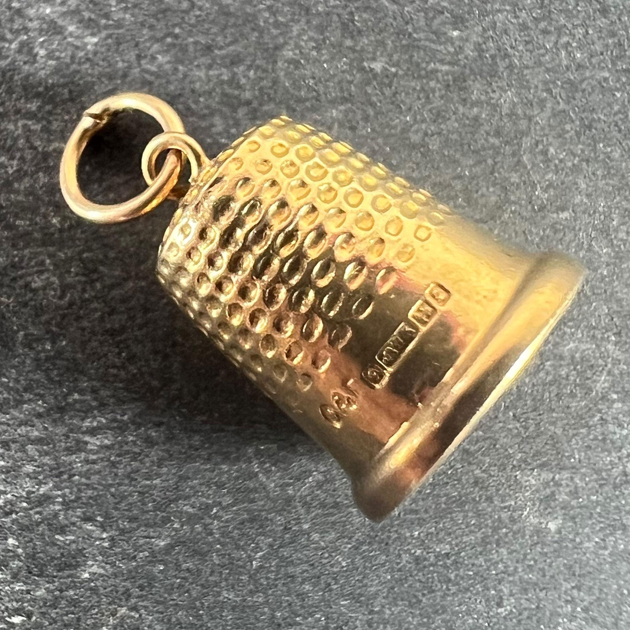 A vintage 9 karat (9K) yellow gold charm pendant designed as a thimble. Hallmarked for Birmingham 1990 and 9 karat gold with maker’s mark C&F for Cropp and Farr.

Dimensions: 1.5 x 1.1 x 0.1 cm (not including jump ring)
Weight: 1.25 grams
(Chain not