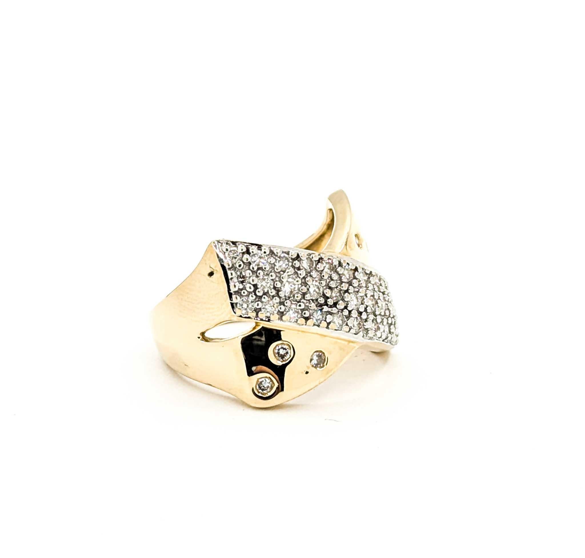 This vintage crossover ring is crafted in 14k yellow gold and showcases approximately .50 carats total weight of round brilliant diamonds. The design features a sweeping crossover band with pavé-set diamonds at the center, accented by additional