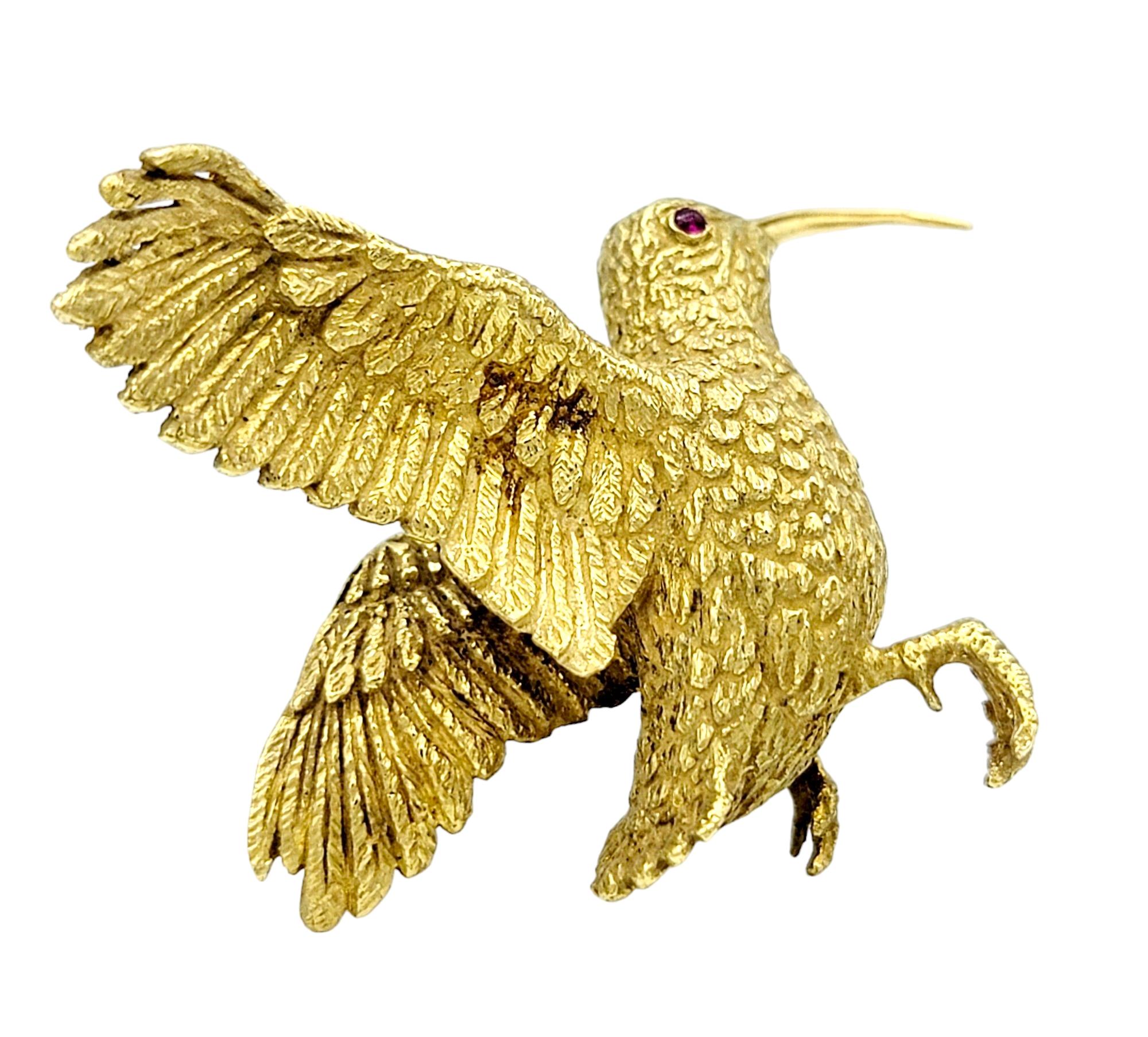 Crafted with exquisite attention to detail, this vintage Crossroads of Sport hummingbird brooch is a testament to elegance and sophistication. Fashioned from lustrous 18 karat yellow gold, this enchanting piece showcases the graceful form of a