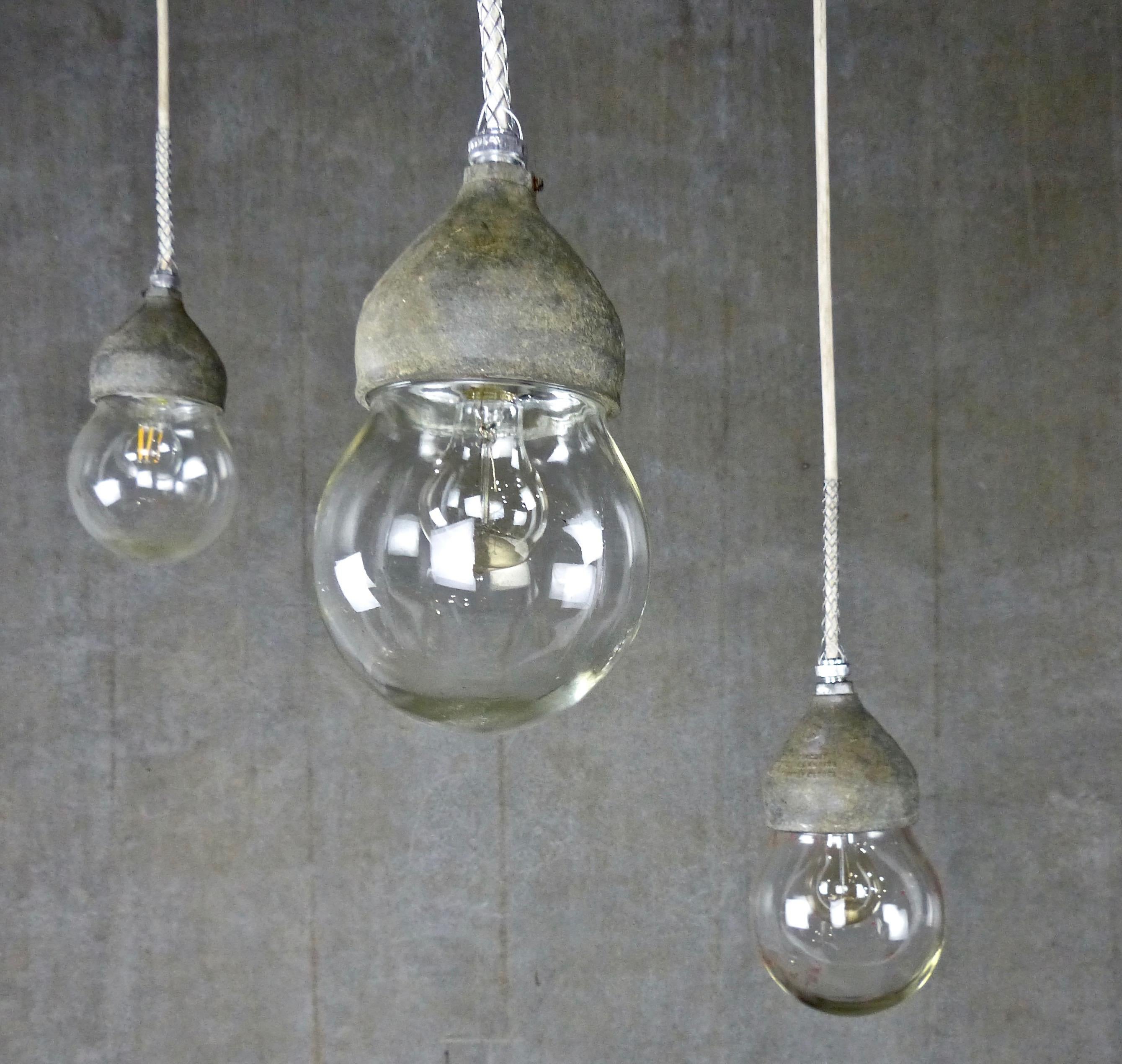 Set of three industrial cast metal and glass globe pendant lights by Crouse Hinds, circa 1930. Authentic design from CH, the leader in industrial lights for over 100 years. Re-wired and CSA approved; ceiling mounting plate included. Currently on 8