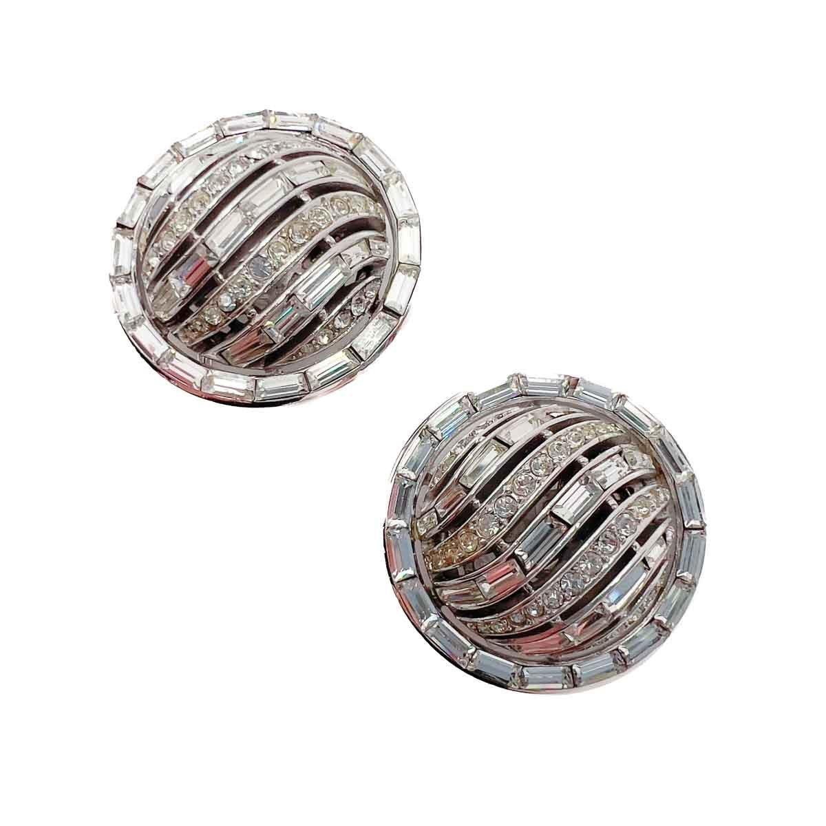 A pair of large eye-catching Vintage Trifari Deco Baguette Earrings. A sublime design featuring a stone rich front. The stones set in swathes across and around the design. The baguette crystal cut adding to the Art Deco design rich look. The