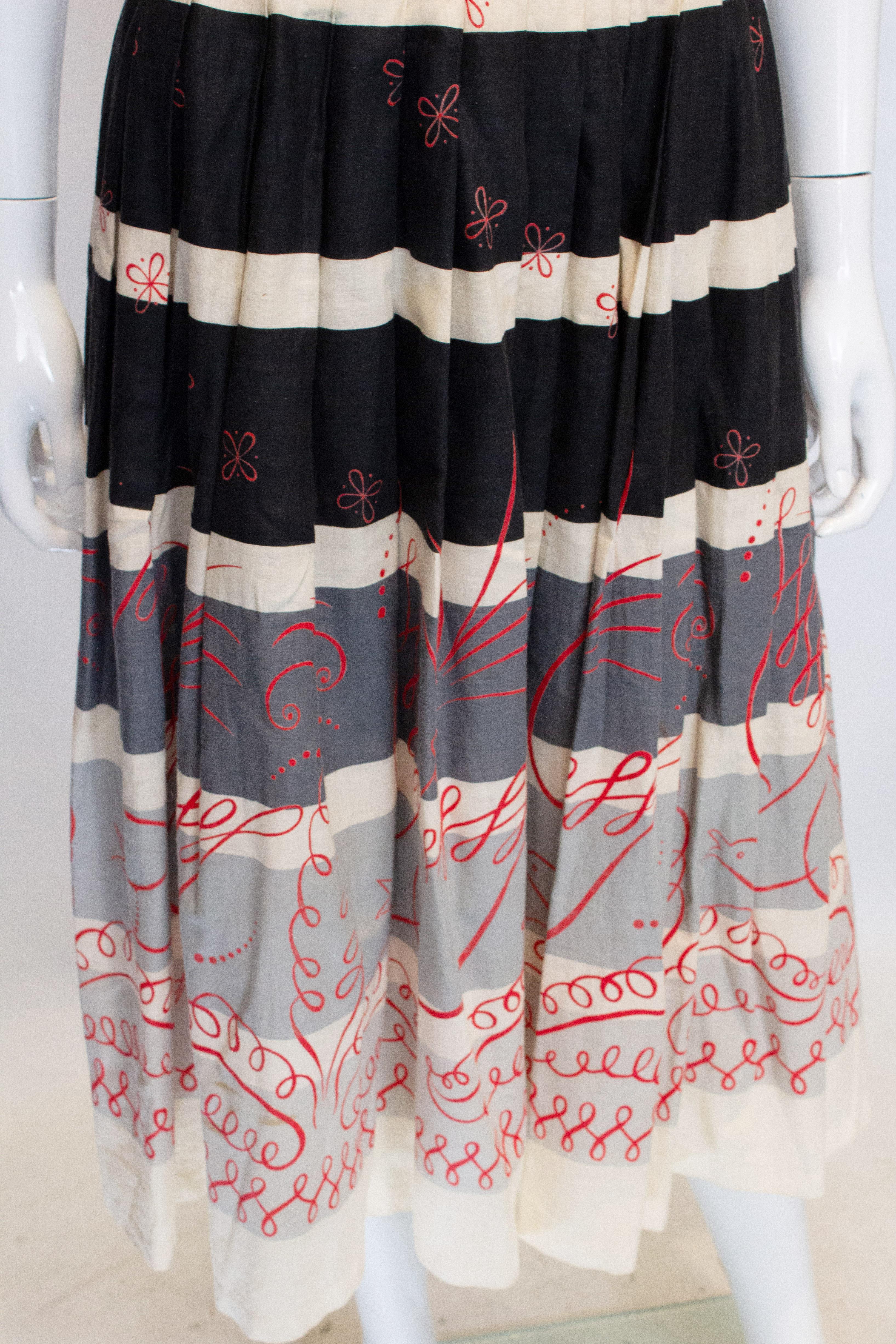 A fun vintage cotton skirt by Cruise Cotton by the Ideal Dress Co Ltd.
The skirt is in a black, white , red and grey print with a side zip opening.