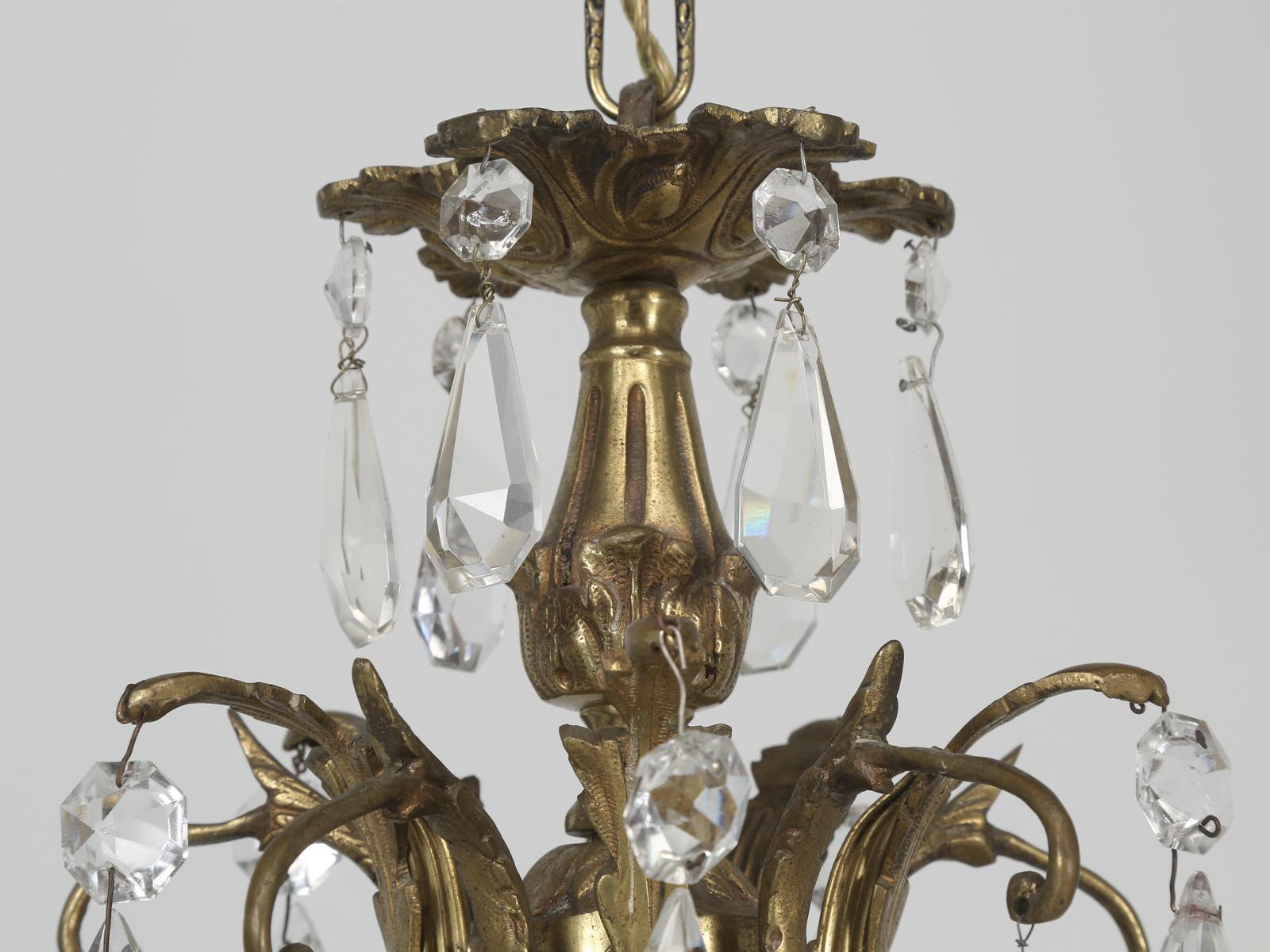 An almost antique chandelier for we believe it is probably only 80-90-years old. Had we priced this crystal and bronze chandelier by the pound we could have doubled our asking price. Very heavy bronze frame that appears to have been gilded and the