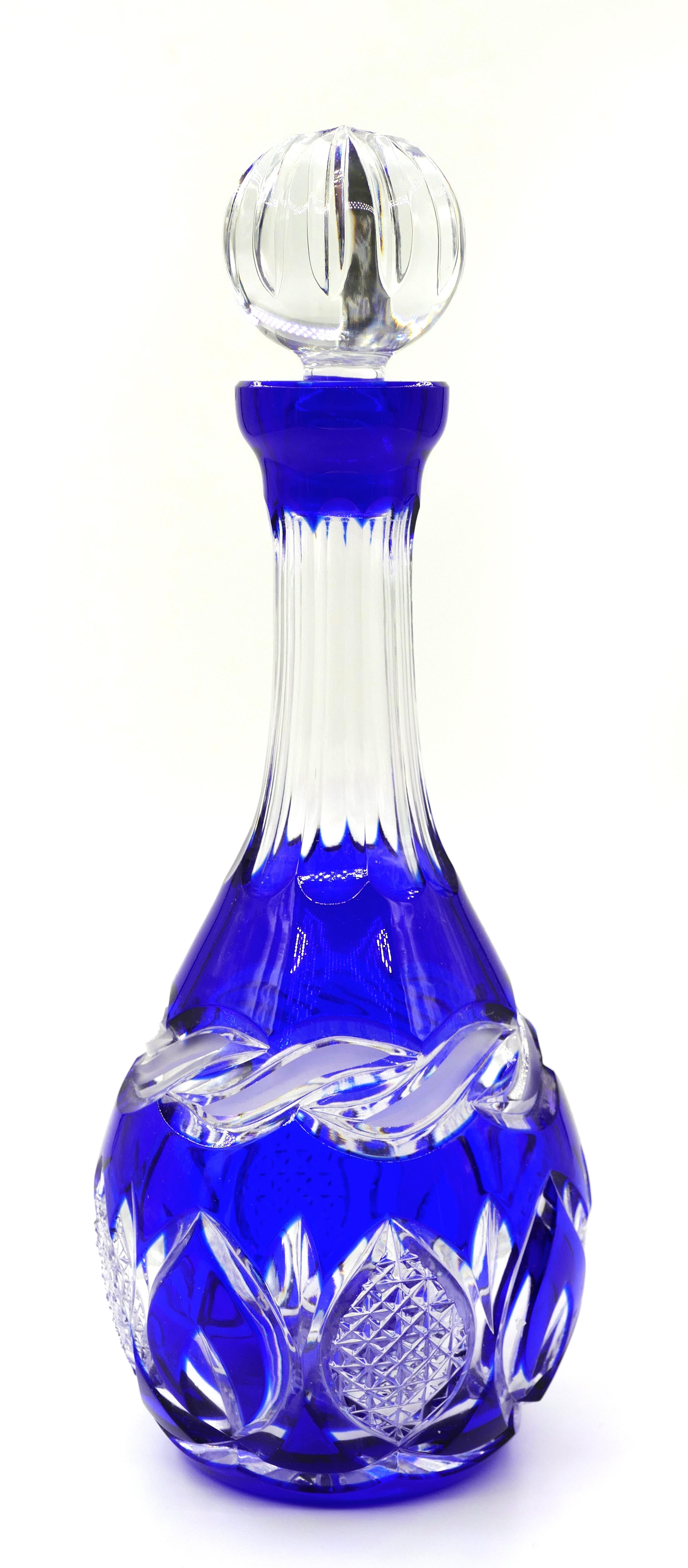 This is a crystal carafe, surely produced in the second half of 20th century and probably a fine Bavarian crystal by Nachtmann. 

This precious Cobalt blue crystal carafe with a transparent crystal Bouchon, has a transparent geometric motive