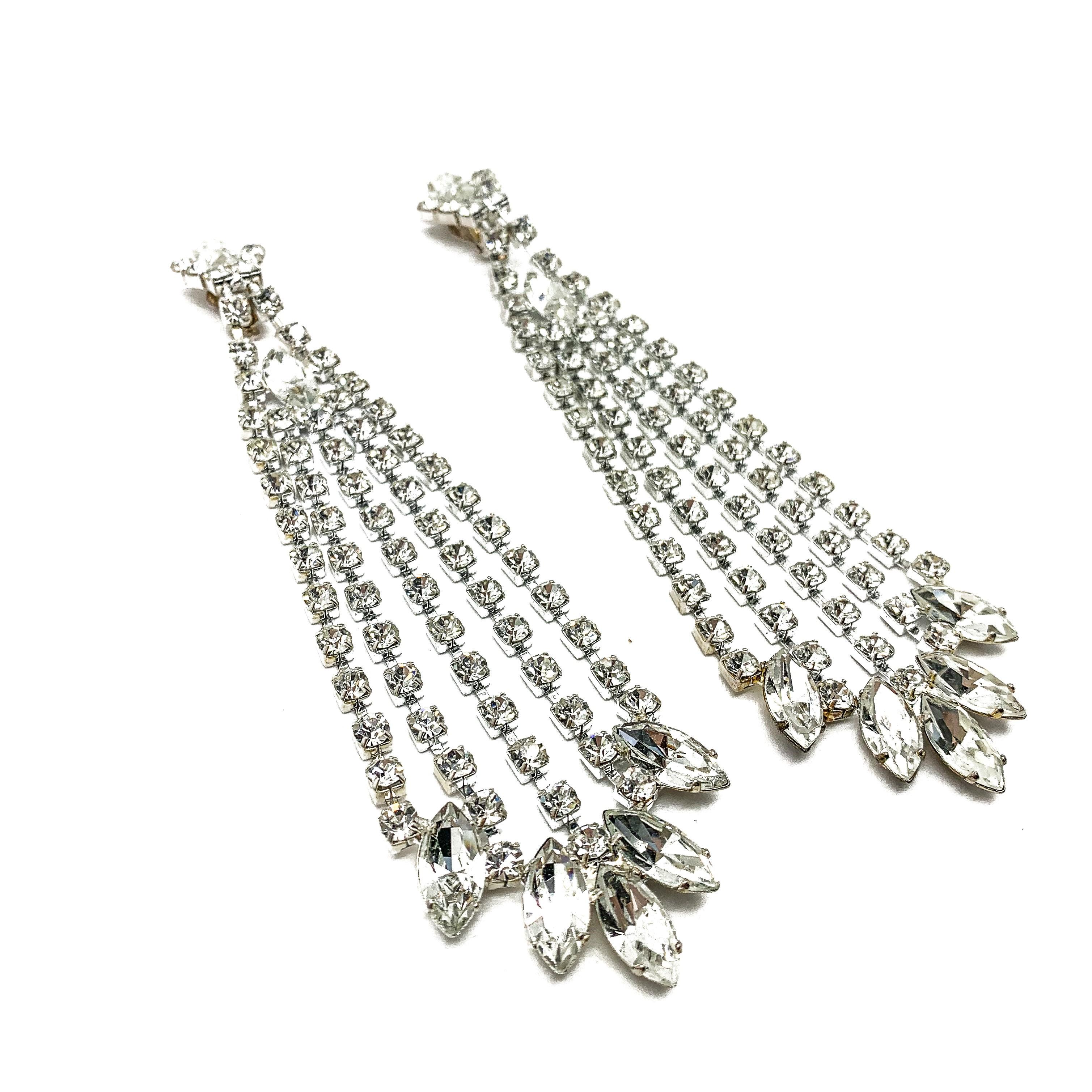 A spectacular pair of Vintage Crystal Chandelier Earrings. Crafted in silver-tone metal and crystals. These incredibly proportioned earrings take no prisoners. The neat clip on top dropping away dramatically to a five rows of crystals culminating in