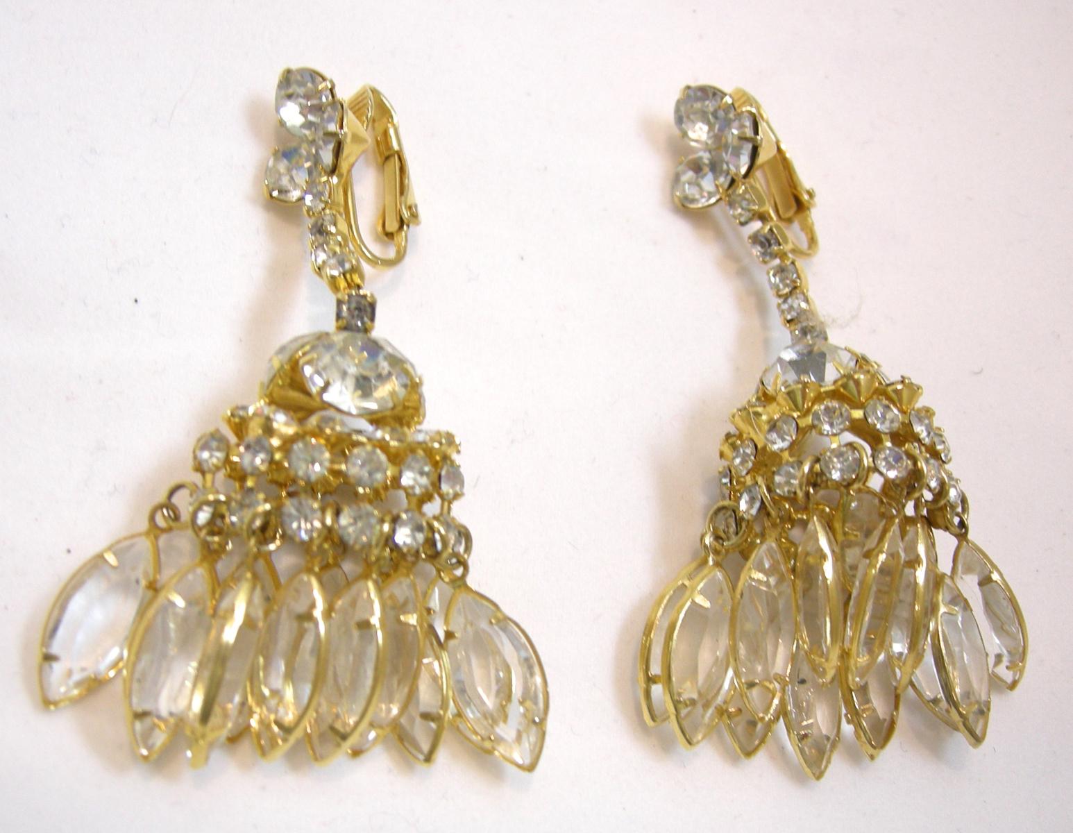 These vintage earrings have three crystals on top with a row of crystals leading to a chandelier design with different shape crystals.  It is in a gold-tone setting.  In excellent condition, these clip earrings measure 2-1/2” x 1”.