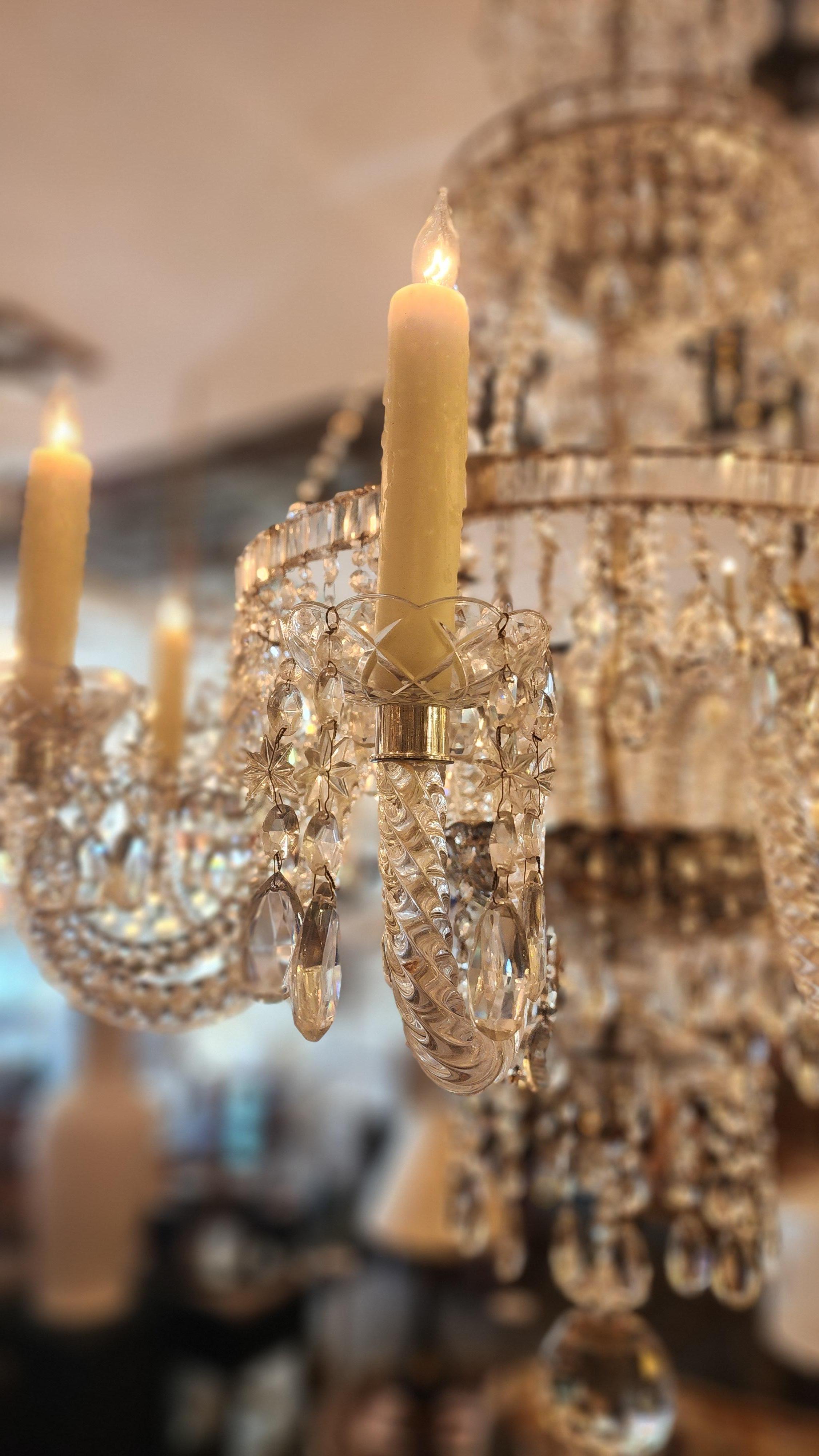 Lampadario in cristallo vintage con più livelli di prismi e gocce di cristallo tagliati a mano. La corona superiore è drappeggiata con fili di cristallo a forma di cascata, mentre le file inferiori sono riccamente stratificate con pendenti