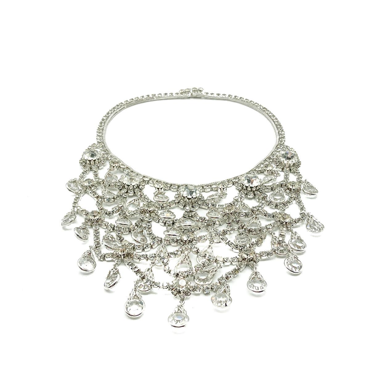 A Vintage Crystal Festoon Necklace from the 1950s. An exquisite and rare find. Featuring rows and rows of individually claw set crystals festooned to huge effect from an end to end rhinestone encrusted collar. Small crystal droplets set in filigree