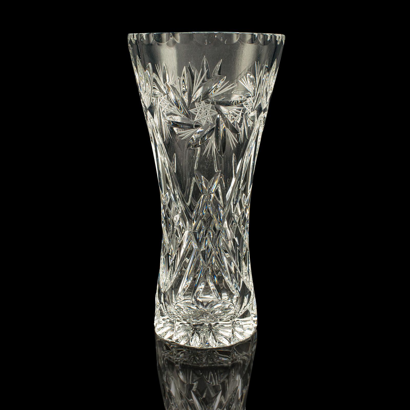 Se trata de un jarrón vintage de cristal para flores, con atractivos detalles de cristal tallado y fina artesanía inglesa, que data de mediados del siglo XX, hacia 1940. Una pieza bellamente presentada, ideal para exponer arreglos florales o como