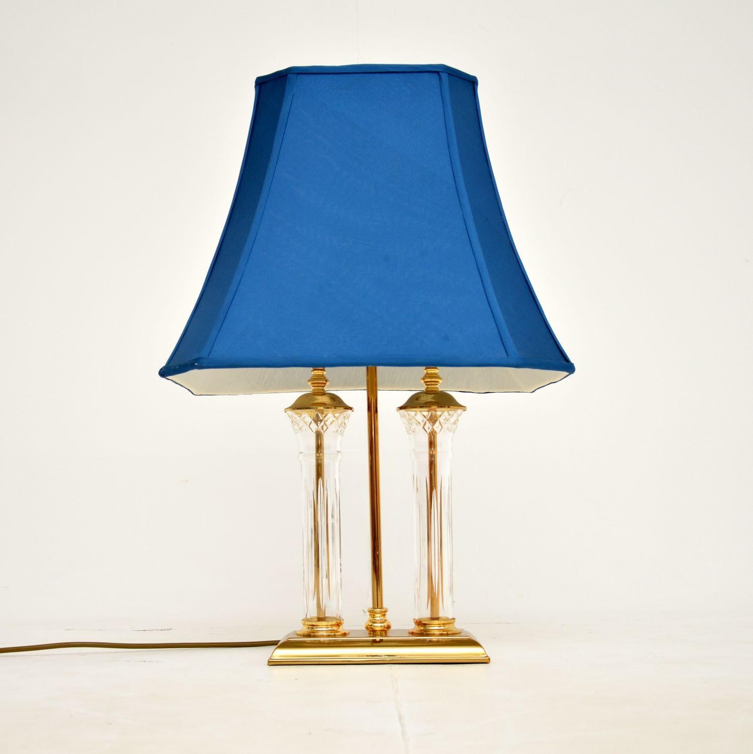 A beautiful vintage table lamp in the classic antique style. This was made in England, it dates from around the 1970’s.

It is of extremely high quality, made from cut crystal glass and solid brass. This has the original blue silk shade, which