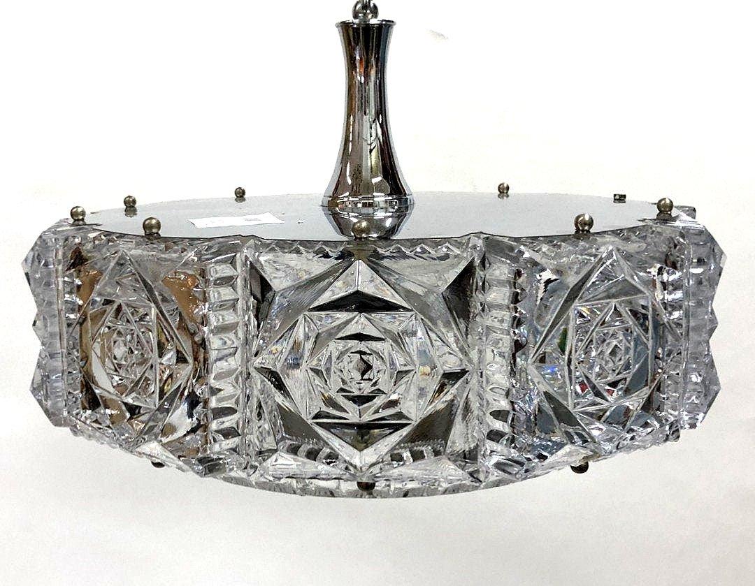 This 1960s-1970s era chiseled Chrystal glass chandelier features chrome-plated accessories and is in good condition.