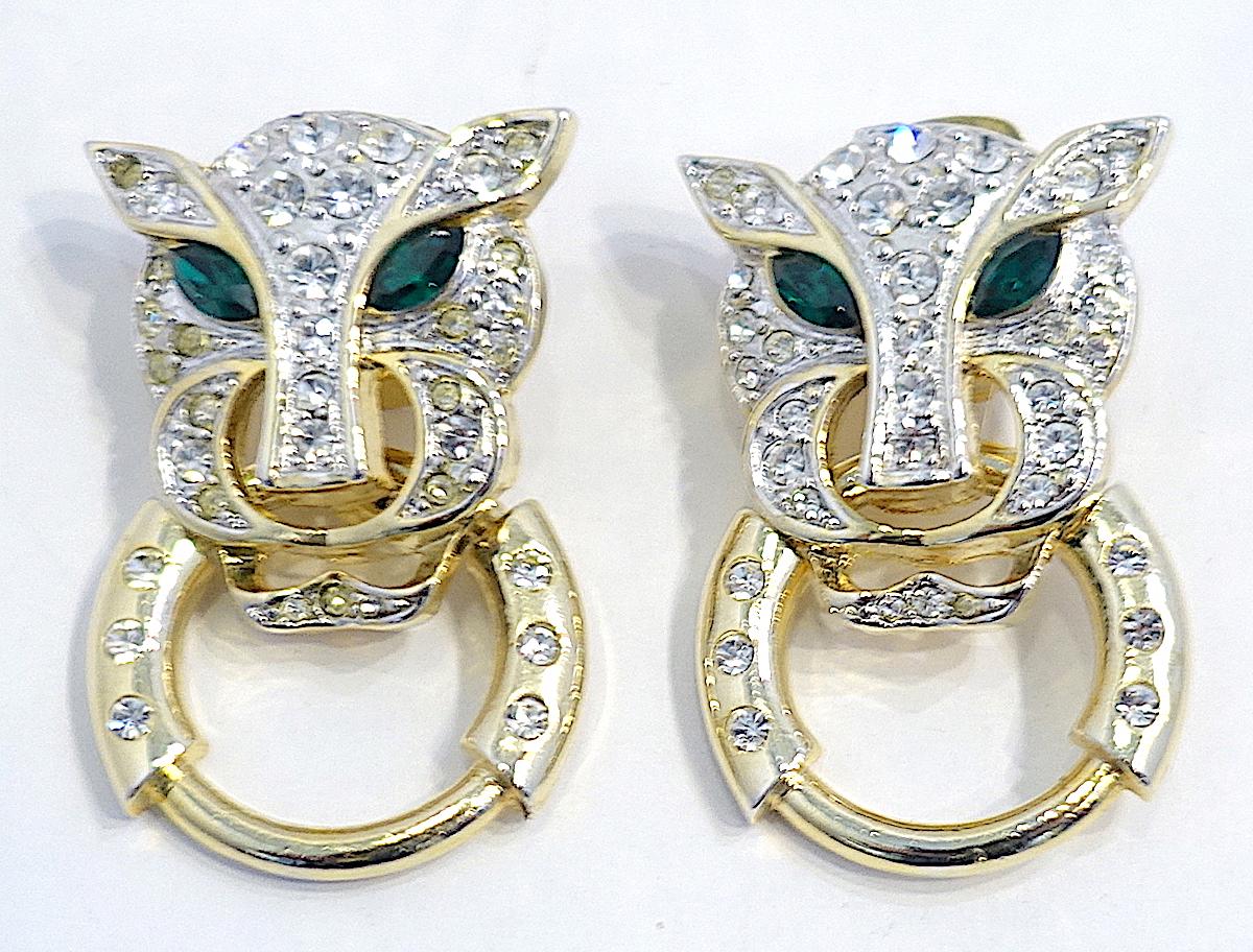 These vintage leopard earrings have clear crystals throughout its head with green crystal eyes.  A hoop (some call it a door knocker) hangs from its mouth.  They are in a gold tone setting. These clip earrings measure 1-1/2” x 1” and are in