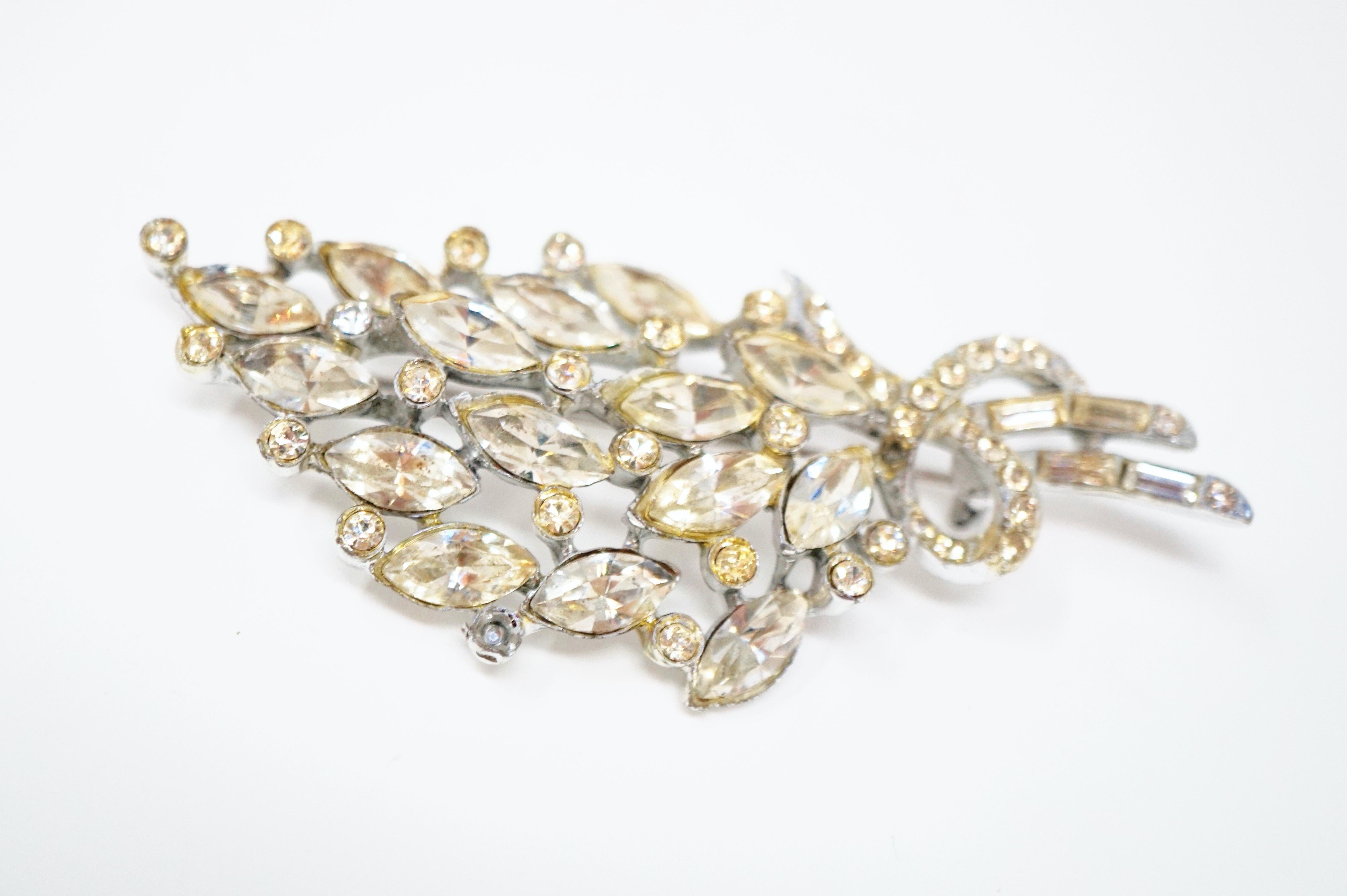 Beautiful vintage crystal rhinestone bouquet brooch with silver tone hardware, circa 1950s. A classic accessory for wedding or formal looks. This brooch is comprised of a medley of sparkling baguette, marquise and round crystal rhinestones in a