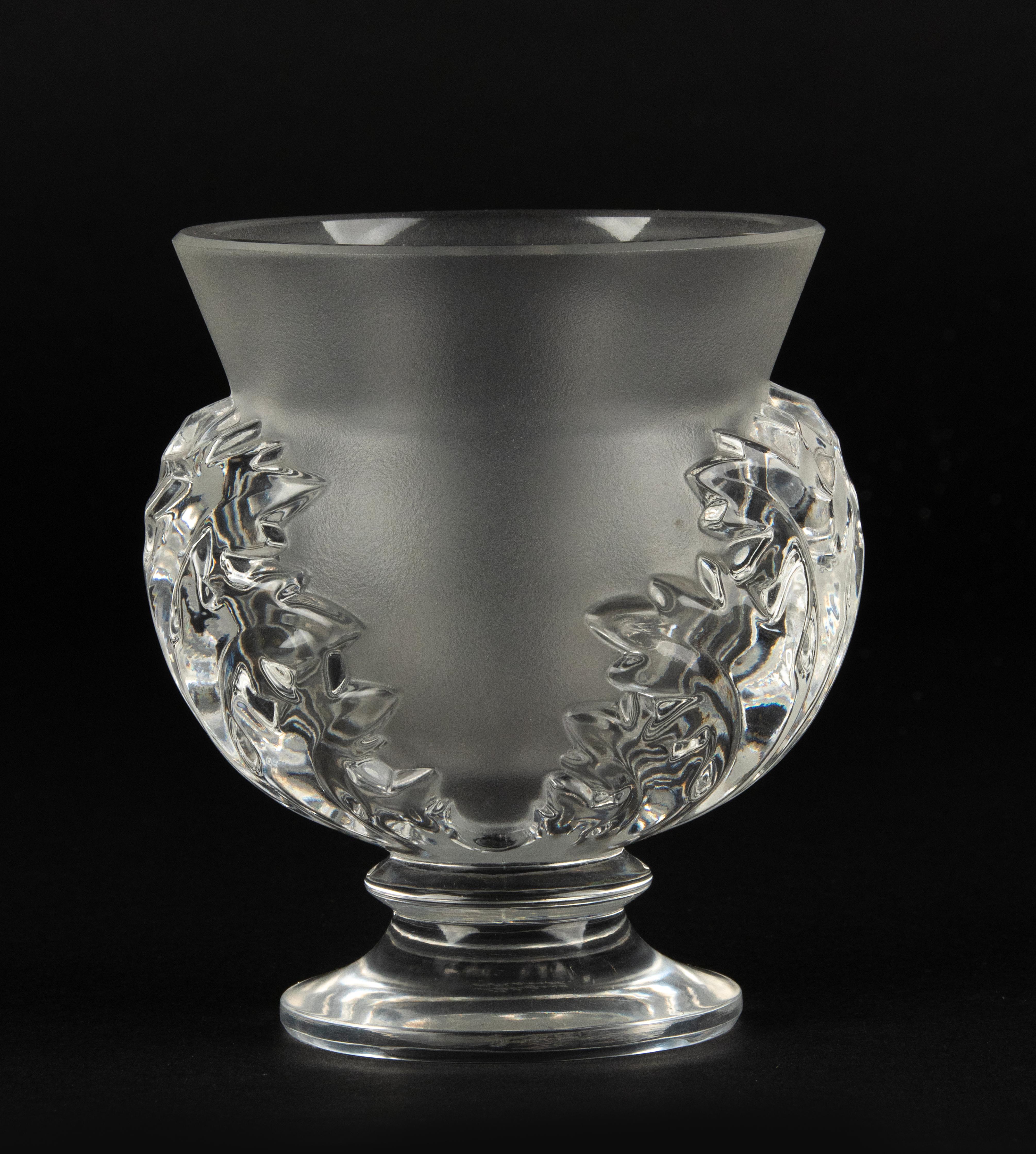 Un joli petit vase en cristal, fabriqué par la marque française Lalique. 
Le nom du modèle est Saint Cloud. 
Le vase est en très bon état. Il n'y a pas d'ébréchures ni de lignes de démarcation. 
Signé en bas. 

Dimensions : 10 x 11 cm et 12 cm de