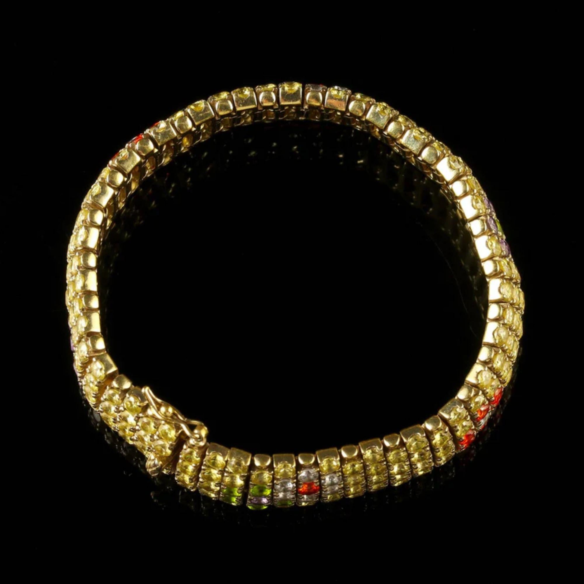 A remarkable vintage cubic zirconia bracelet made by Italian jewellers Ultima Edizione in the late 20th Century. The band is pave set with a dazzling array of golden yellow zirconia with clusters of multi-coloured stones depicting a series of