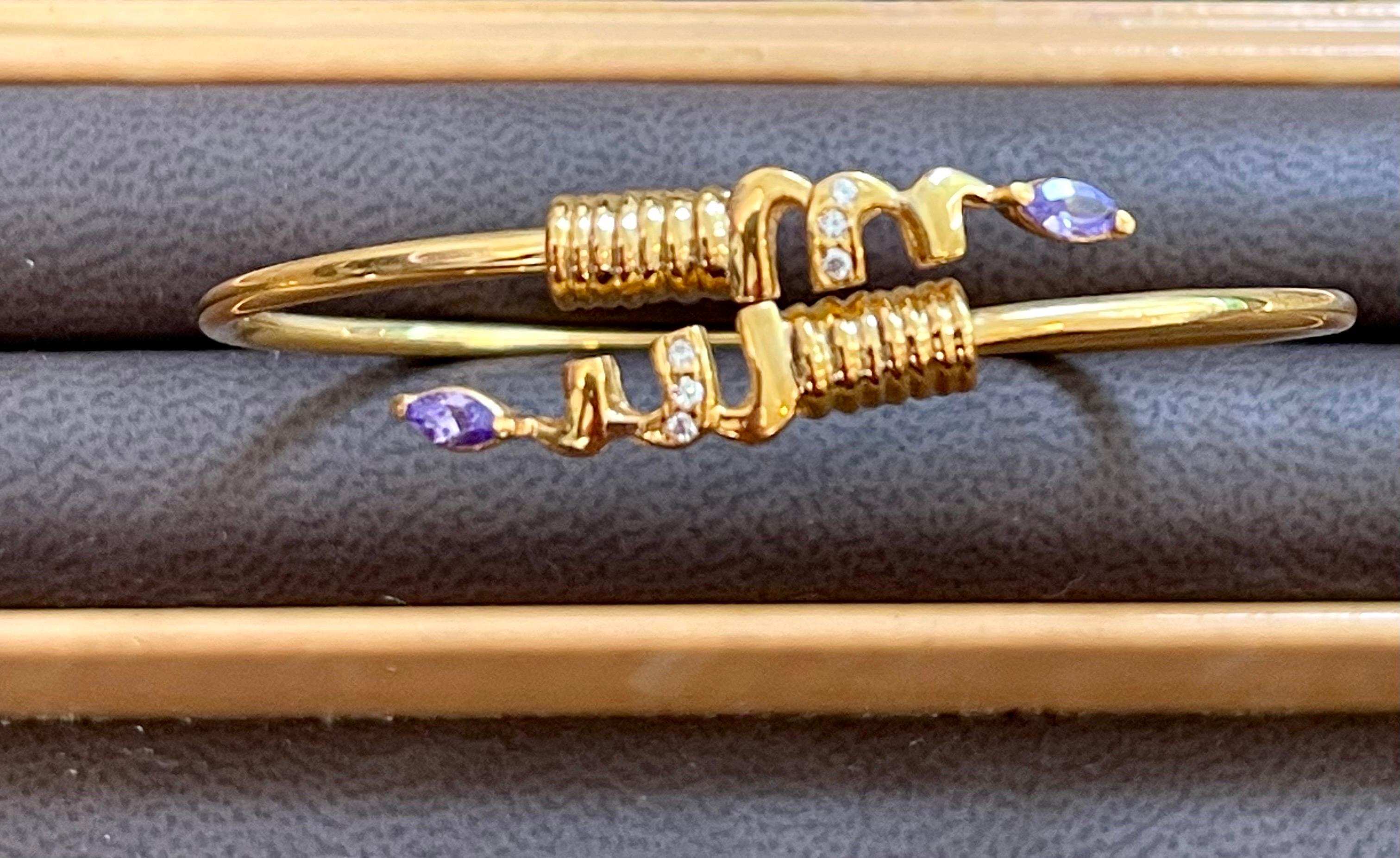 Vintage Cuff Bangle Bracelet 20 Karat Yellow Gold Diamond Tanzanite 8.10 Gram
It features a bangle crafted from an 20 karat  Yellow gold and embedded with  two marquise stones of Amethyst at the ends of the bangle. 
It has some brilliant cut