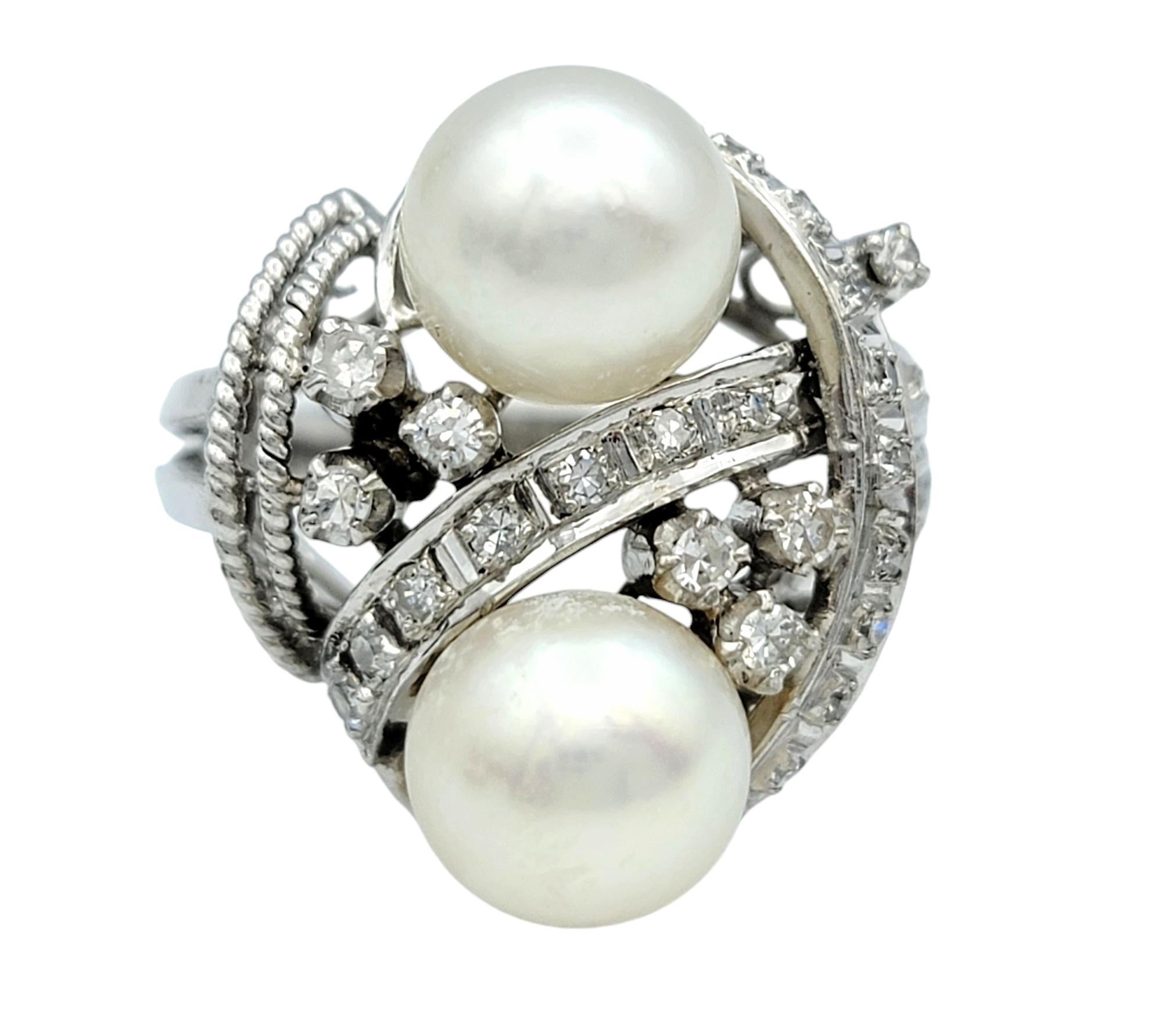 Ring Size: 5.5 

Embrace vintage elegance with this extraordinary platinum ring, featuring two lustrous round pearls stacked vertically for a timeless, sophisticated allure. Each pearl is nestled within a graceful swirl of platinum, adorned with