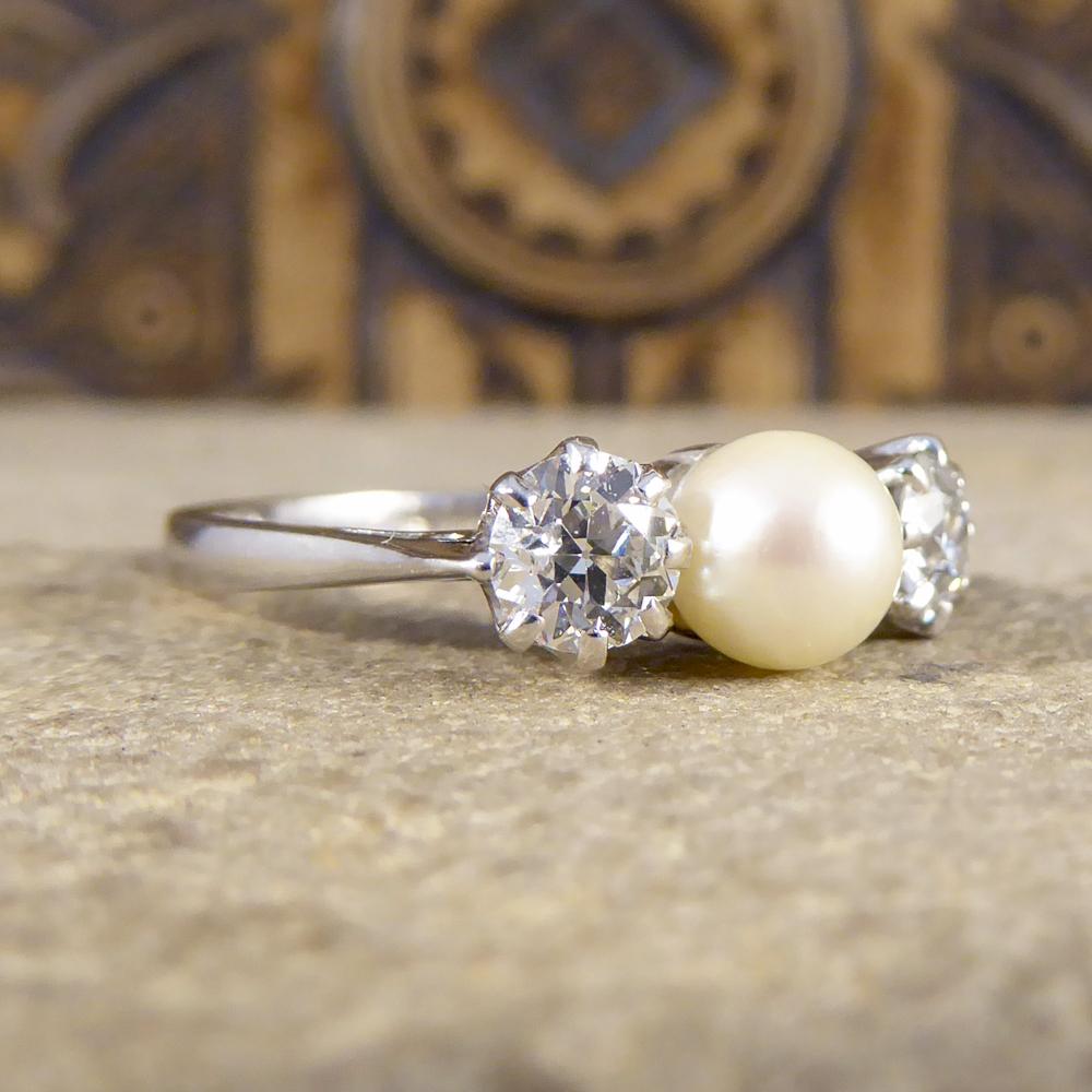 This gorgeous vintage ring holds two bright and clear Old European Cut Diamonds either side of a white cultured Pearl. With clear hallmarks on the inner band showing that the ring has been crafted in 1978 from 18ct White Gold. 

Diamond