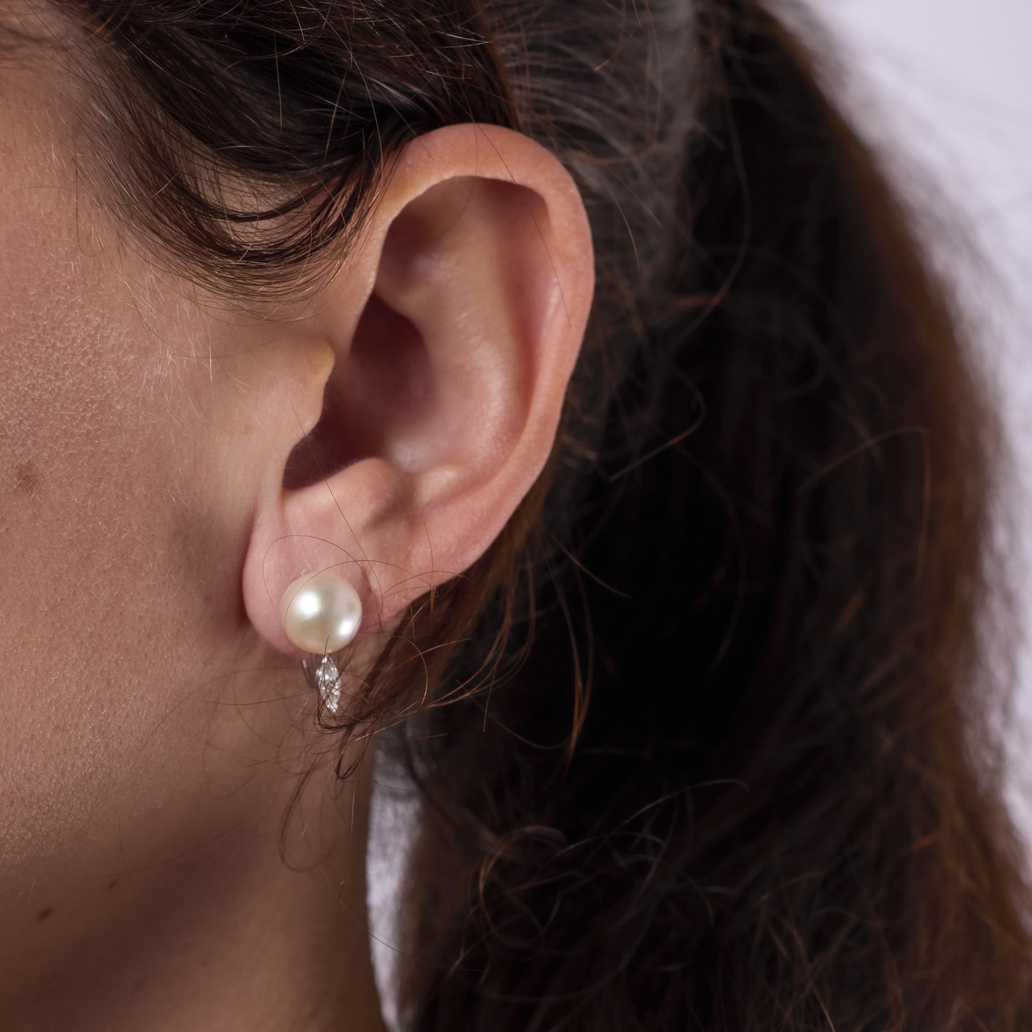Estos pendientes vintage de los años 80 están elaborados en oro blanco de 14 quilates y presentan dos luminosas perlas cultivadas de aproximadamente 9,07 mm. Cada perla está acentuada por un diamante de talla marquesa, con un total aproximado de
