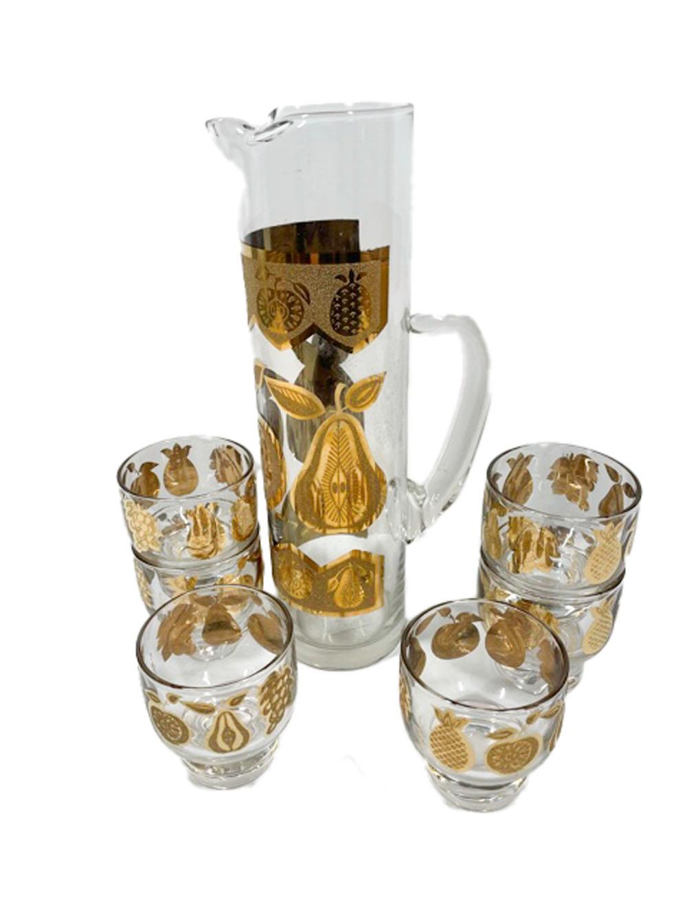 Mid-Century Modern cocktail set by Culver in the Florentine pattern, decorated in smooth and textured 22k gold depicting apple, pear, pineapple and grapes. The set consists of a handled cocktail pitcher and six footed (stacking) cocktail glasses.