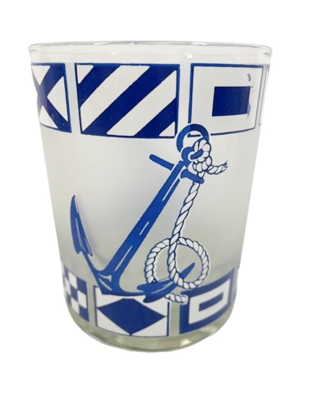 Six verres à pied du milieu du siècle, décorés en bleu et blanc avec de grandes ancres entre deux bandes de drapeaux nautiques, le tout sur un fond givré.