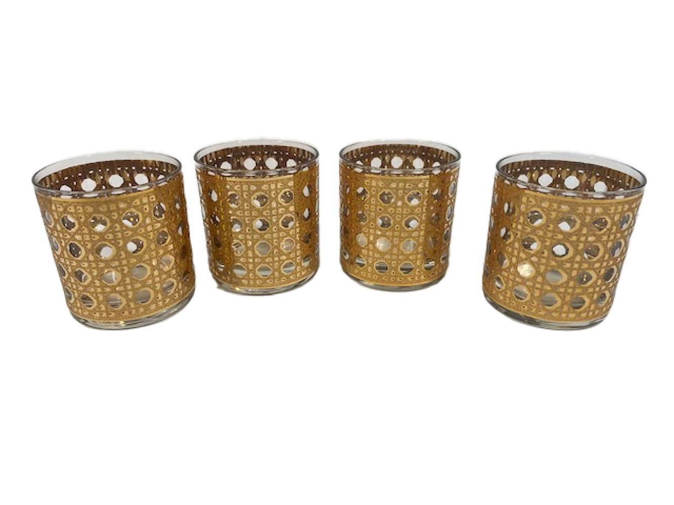 Six-piece cocktail set by Culver, LTD. in the 22 karat gold Canella pattern designed to resemble woven cane. The set consists of a handled cocktail pitcher with pinched pour spout, a glass stirring rod and four cocktail glasses.