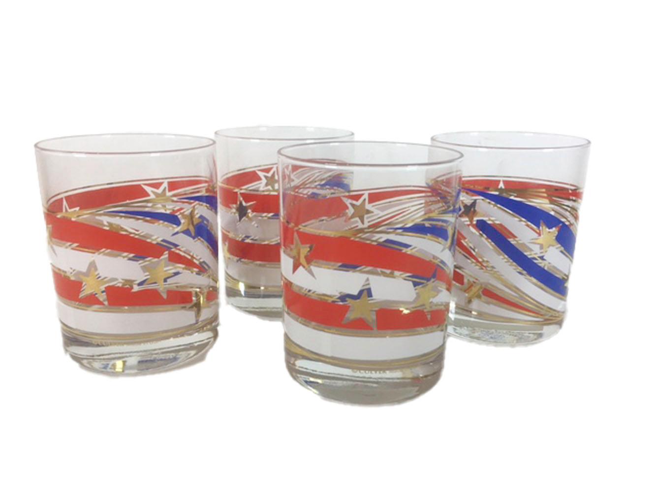 Set of 4 culver rocks glasses with spiral red, white and blue bands divided by lines of gold and with gold stars superimposed throughout creating a celebratory overall pattern.
