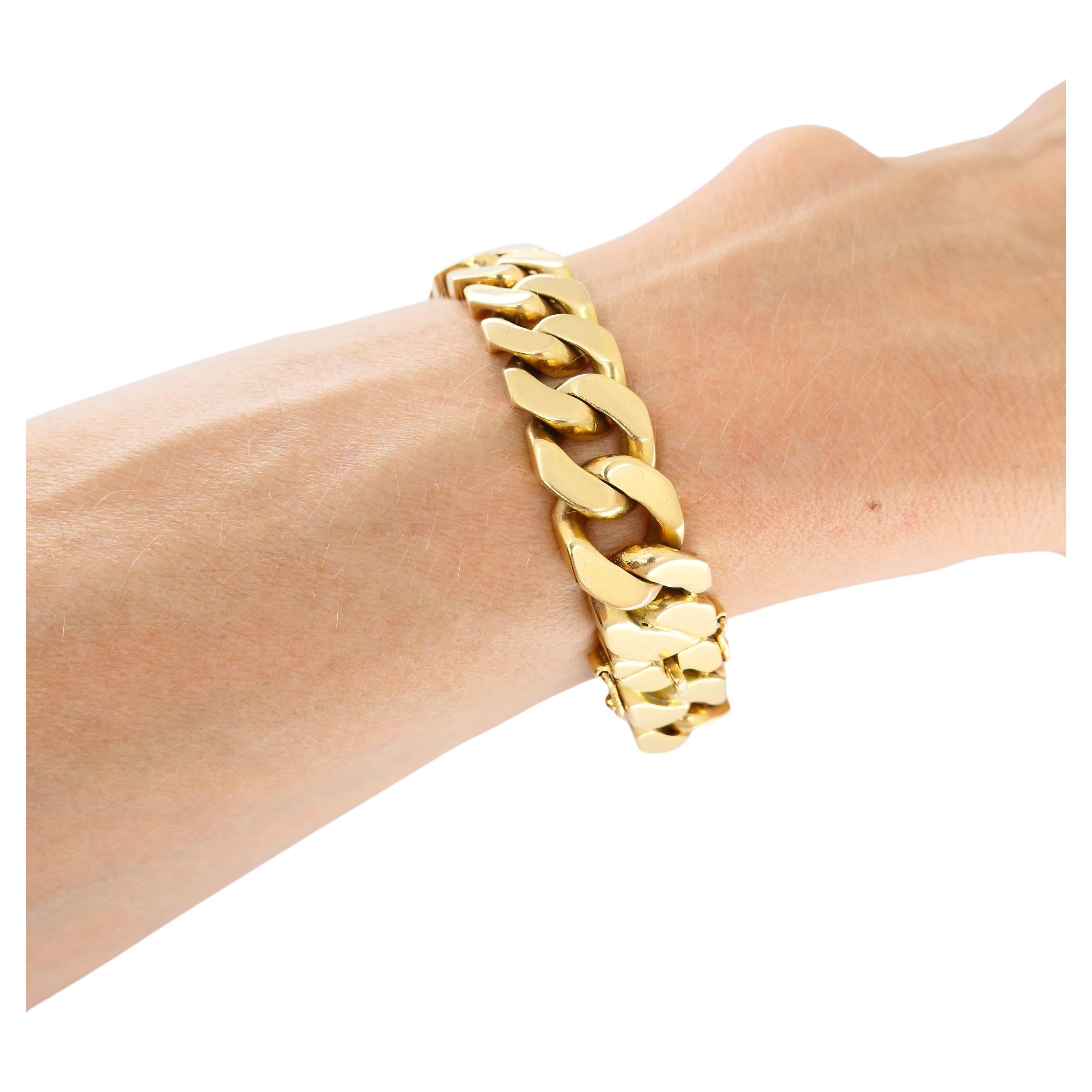 A chunky vintage curb link chain bracelet made of 18k gold, stamped with the French marks. The yellow gold carries a subtle hint of rose, giving it a 'pinkish gold' hue. 
This essential bracelet is perfect for stacking but also makes a statement on