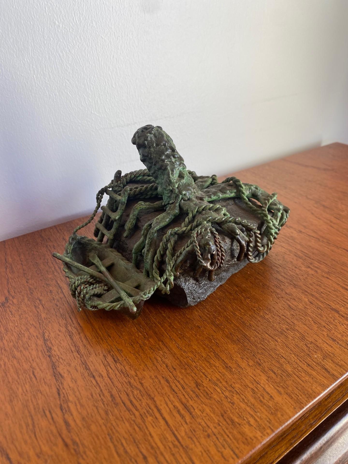 Curtis Clawson (XX secolo) scultura marittima in metallo raffigurante una barca legata a un frammento di albero ramificato. Realizzato in rame o bronzo, ha una patina verde. Firmato CLAWSON a lato. Un'incredibile scultura nostalgica ed evocativa